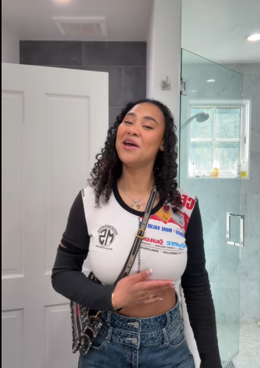 Brianna McKnight lowers the drink and smiles mid-sentence, one hand resting across her stomach, from a post dated February 8, 2025. | Source: TikTok/brimcknighttt