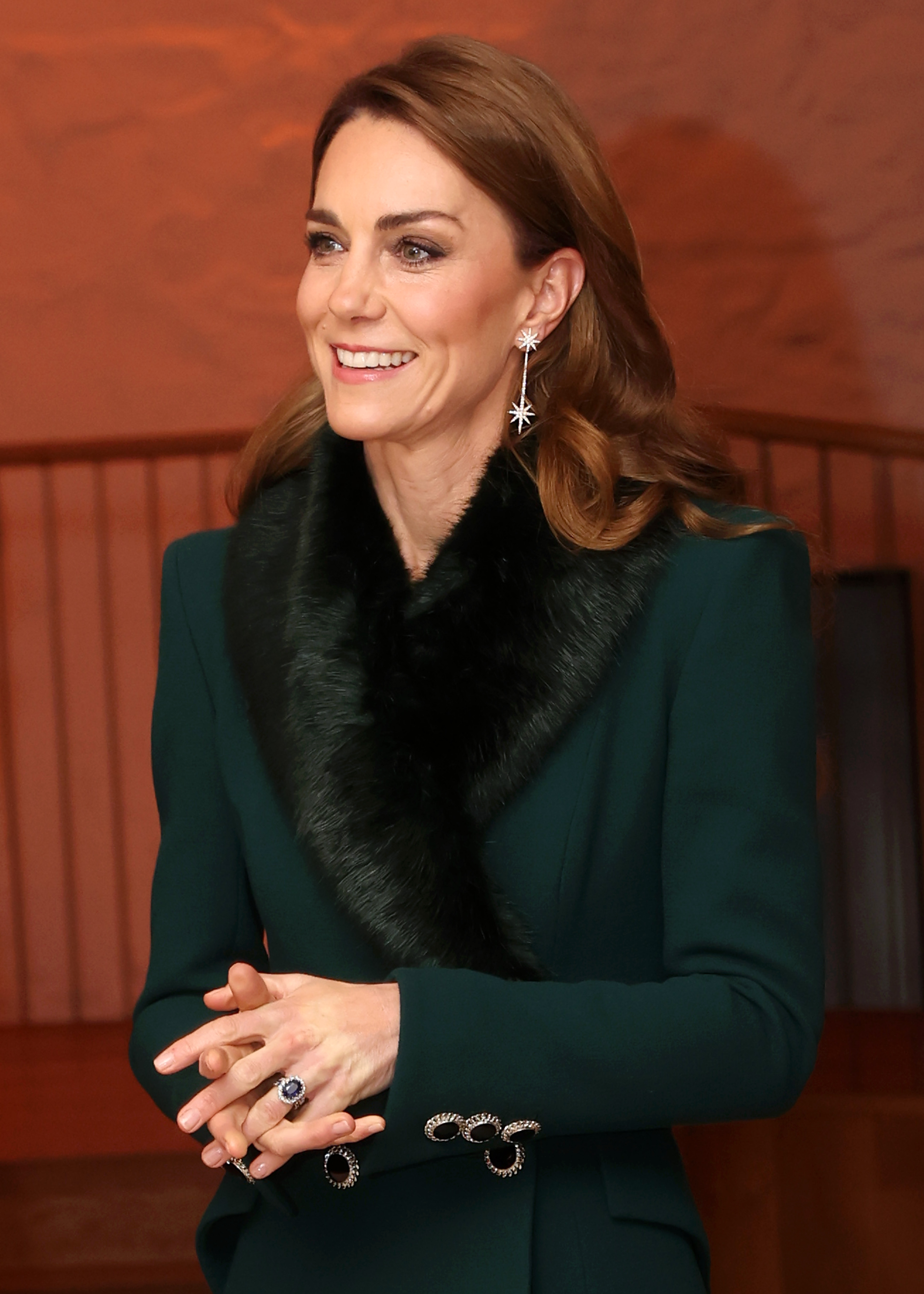 A close-up captured Catherine, Princess of Wales, glowing in the candlelit ambience of the Abbey. Her starburst earrings and sapphire engagement ring subtly echoed the regal yet modern elegance she brought to the fifth annual "Together at Christmas" service.
