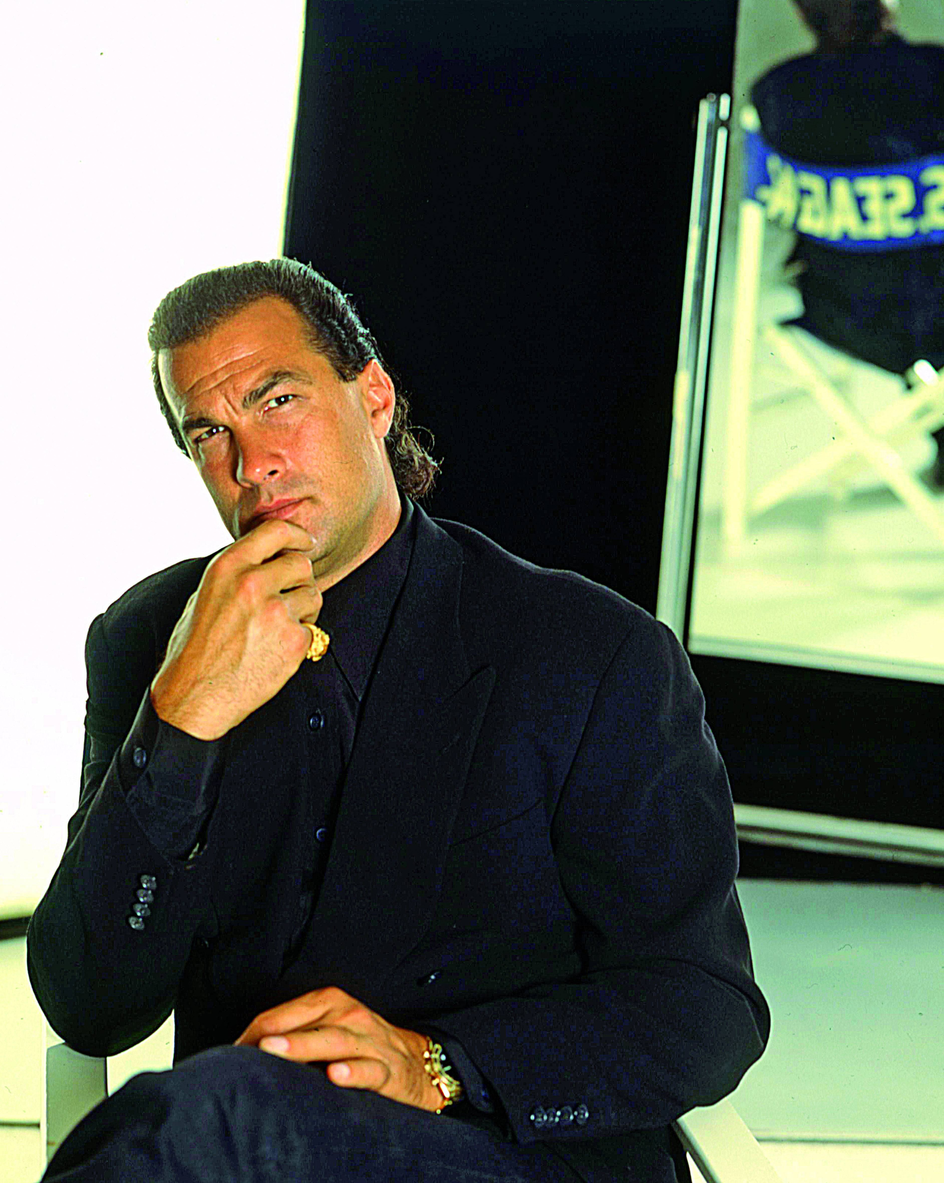 Actor and screenwriter Steven Seagal posing while resting his hand on his chin, wearing a black suit on May 8, 1995 in Milan. / Source: Getty Images