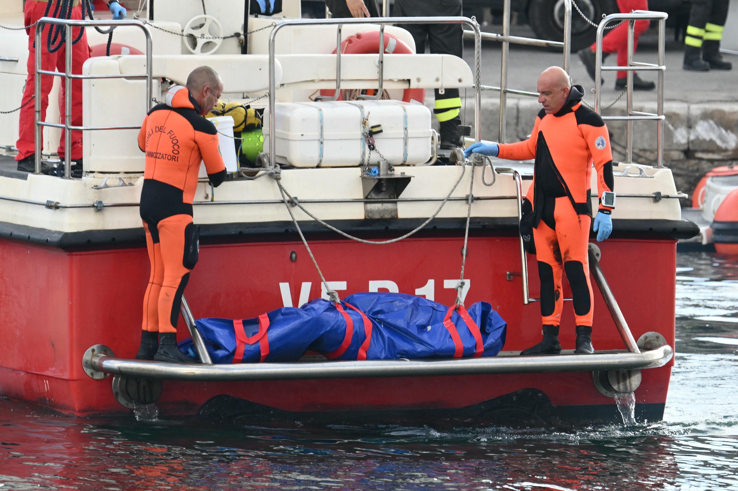 Rescuers carry a body after divers return in Porticello harbor near Palermo, on August 22, 2024, three days after the British-flagged luxury yacht Bayesian sank. | Source: Getty Images