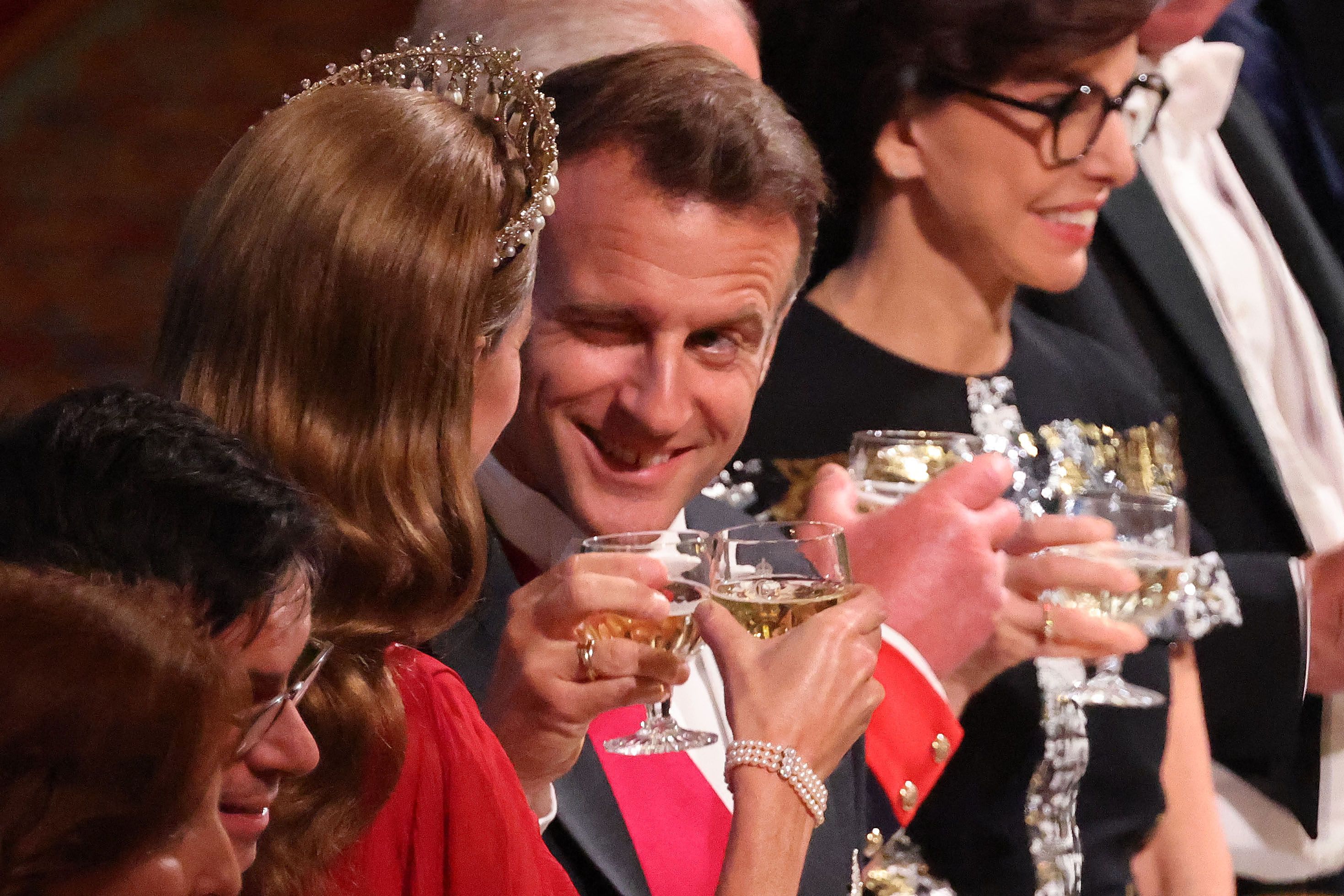 French President Emmanuel Macron shares a playful wink with Catherine, Princess of Wales, as they raise their glasses during a state banquet at Windsor Castle.