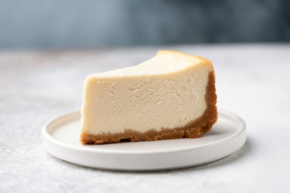 A photo of a slice of cheesecake on a white plate. | Photo: Shutterstock