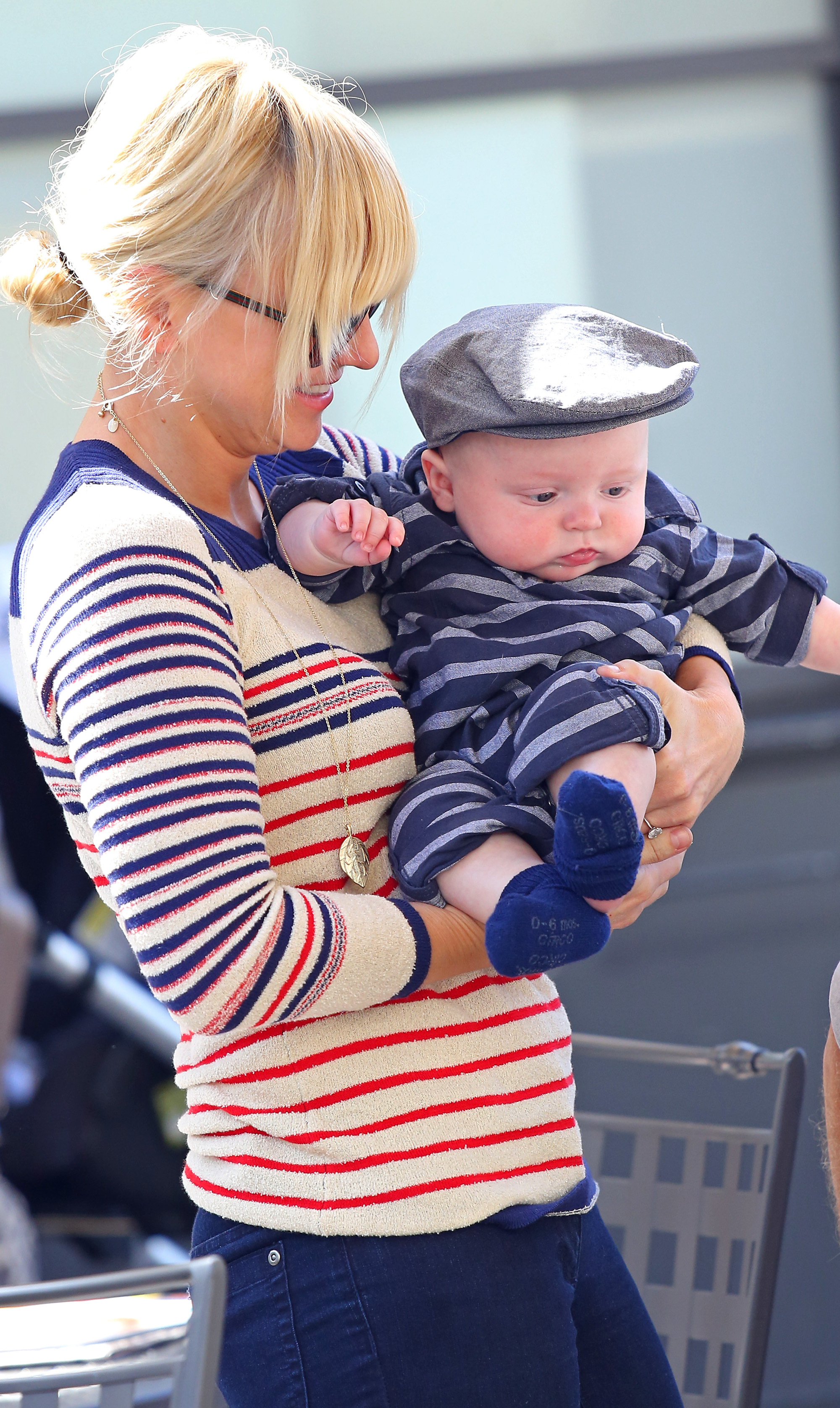 Anna Faris cradles infant son Jack Pratt during a family outing at The Grove. The actress kept things casual as she carried the little one, who wore a striped outfit and newsboy cap while taking in the surroundings.