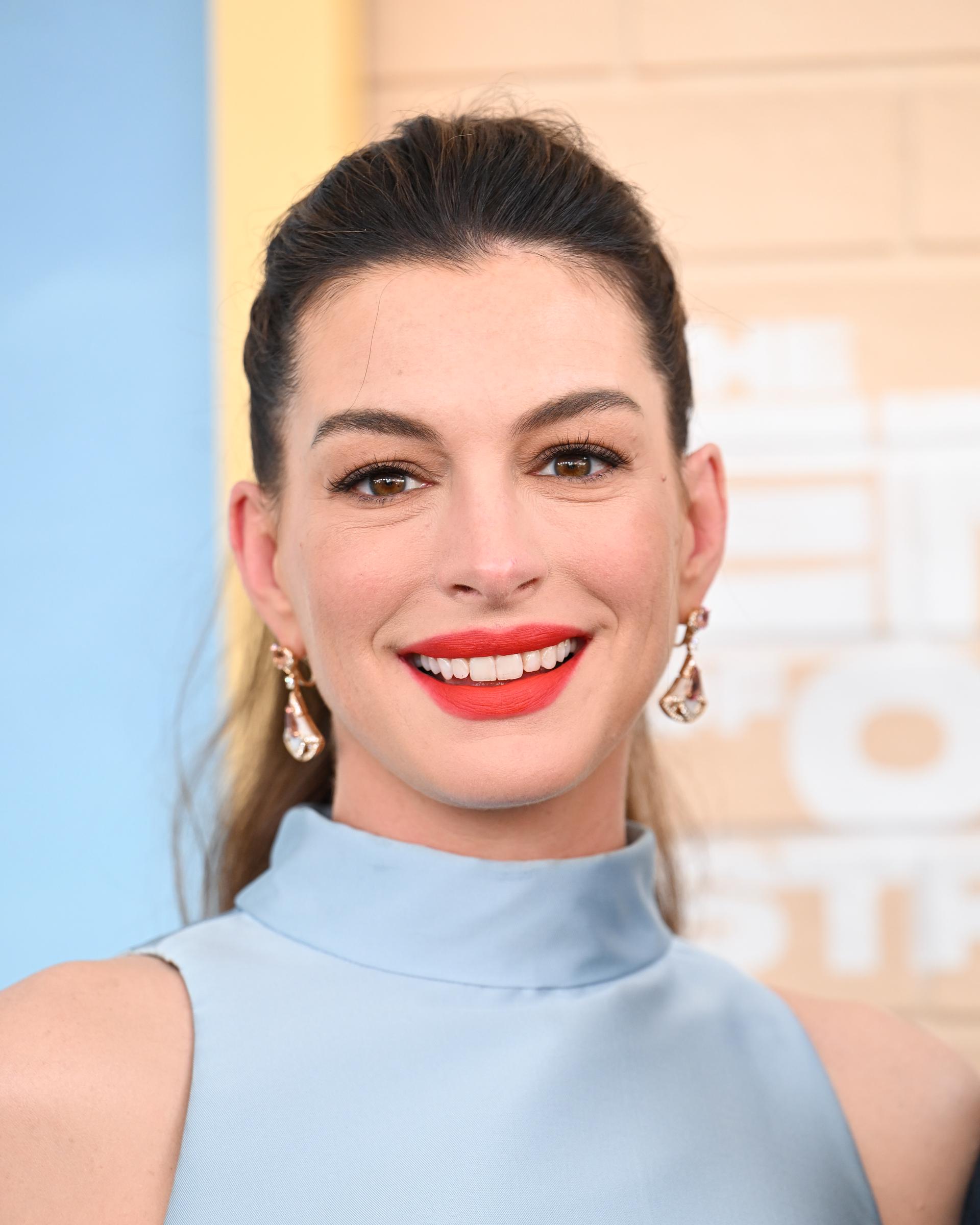 The bright smile offers a more intimate glimpse of Anne Hathaway's red-carpet appearance before the photos reveal the detail that drew the most attention. | Source: Getty Images