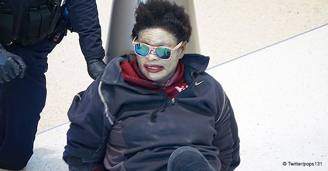 Woman wearing white face paint and sunglasses at airport shouts obscenities, police handcuff her