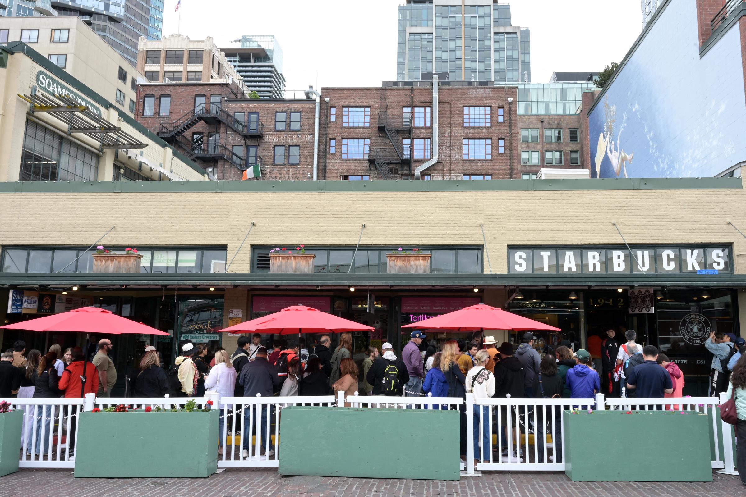 People queueing outside the first Starbucks coffee shop, which opened in 1971, in front of Pike Place Market in downtown Seattle on June 25, 2025  | Source: Getty Images