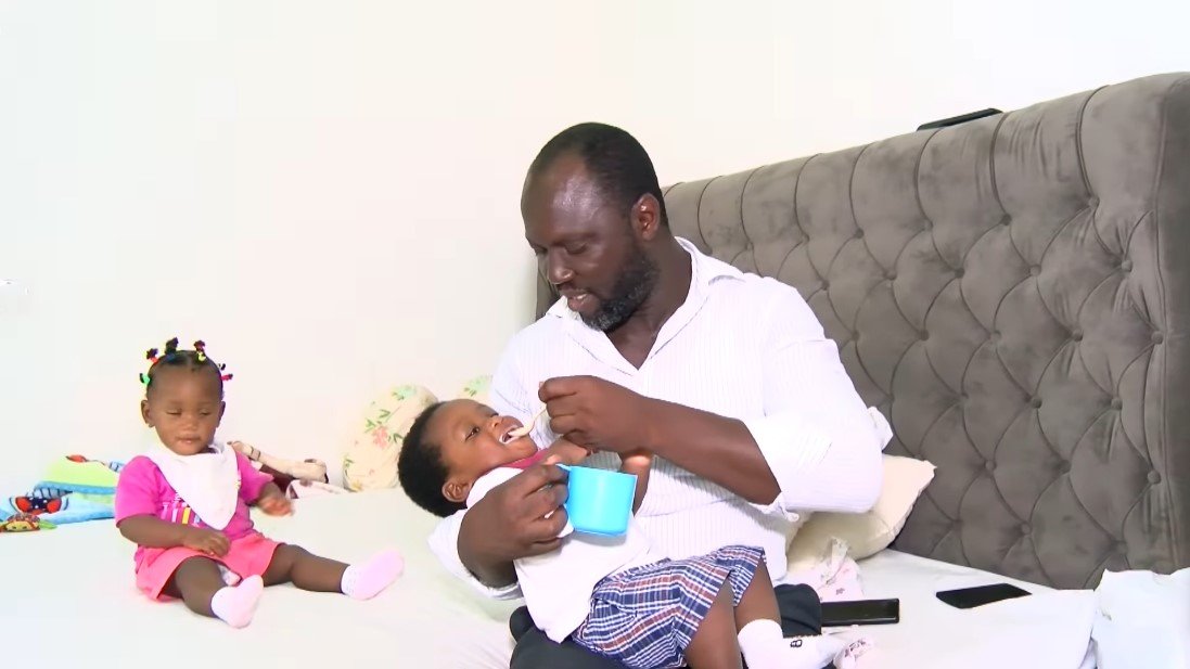 Edmund Akrofi alimentando a sus gemelos. | Foto: Youtube/Joy Learning Tv