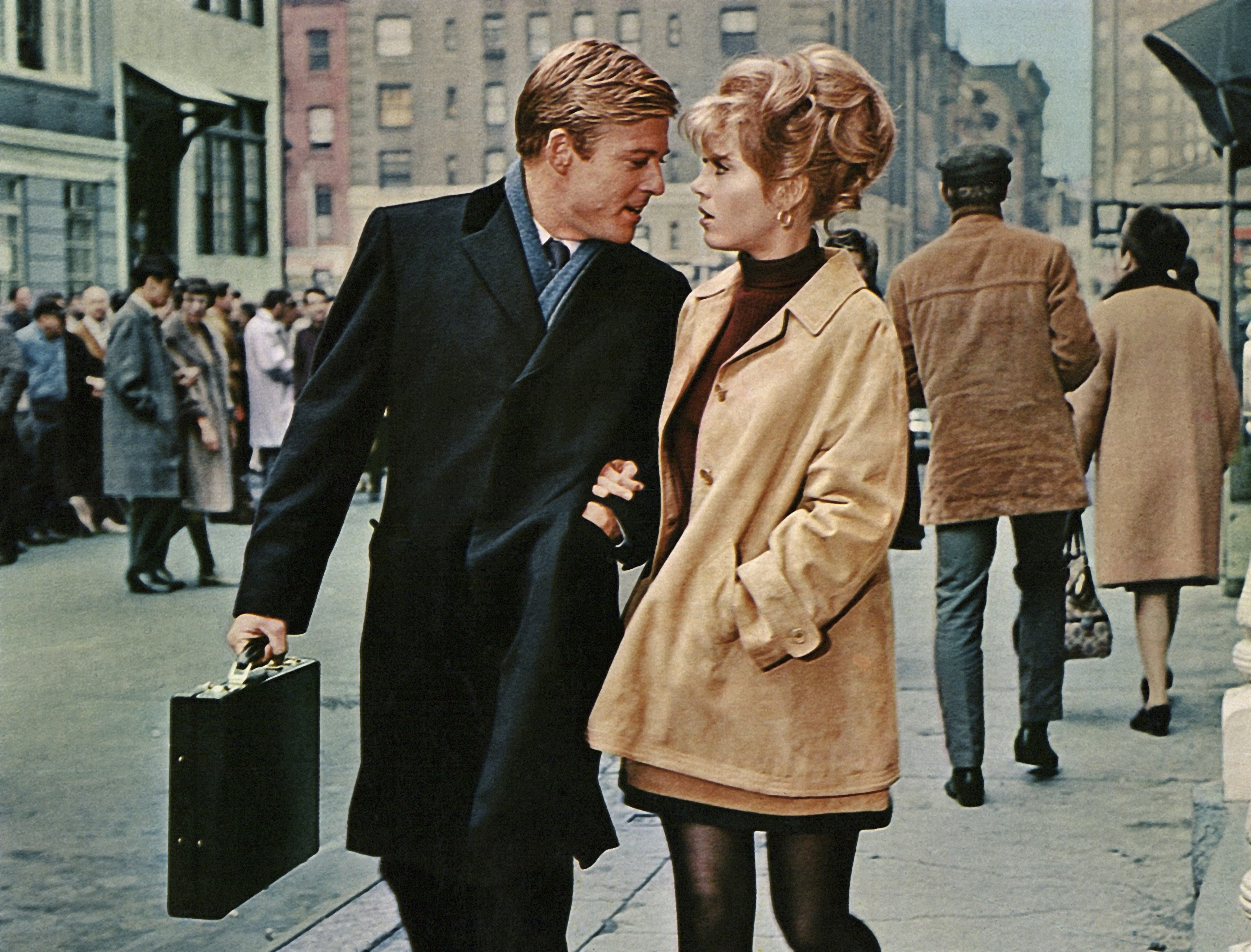 Robert Redford and Jane Fonda walking arm in arm on a Manhattan street from the 1967 film "Barefoot in the Park." Redford leans in seemingly for a kiss as Fonda gazes at him tenderly.