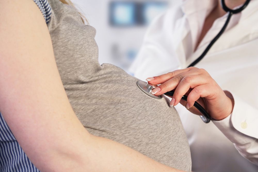 Eine Ärztin untersucht eine schwangere Mutter. | Quelle: Shutterstock