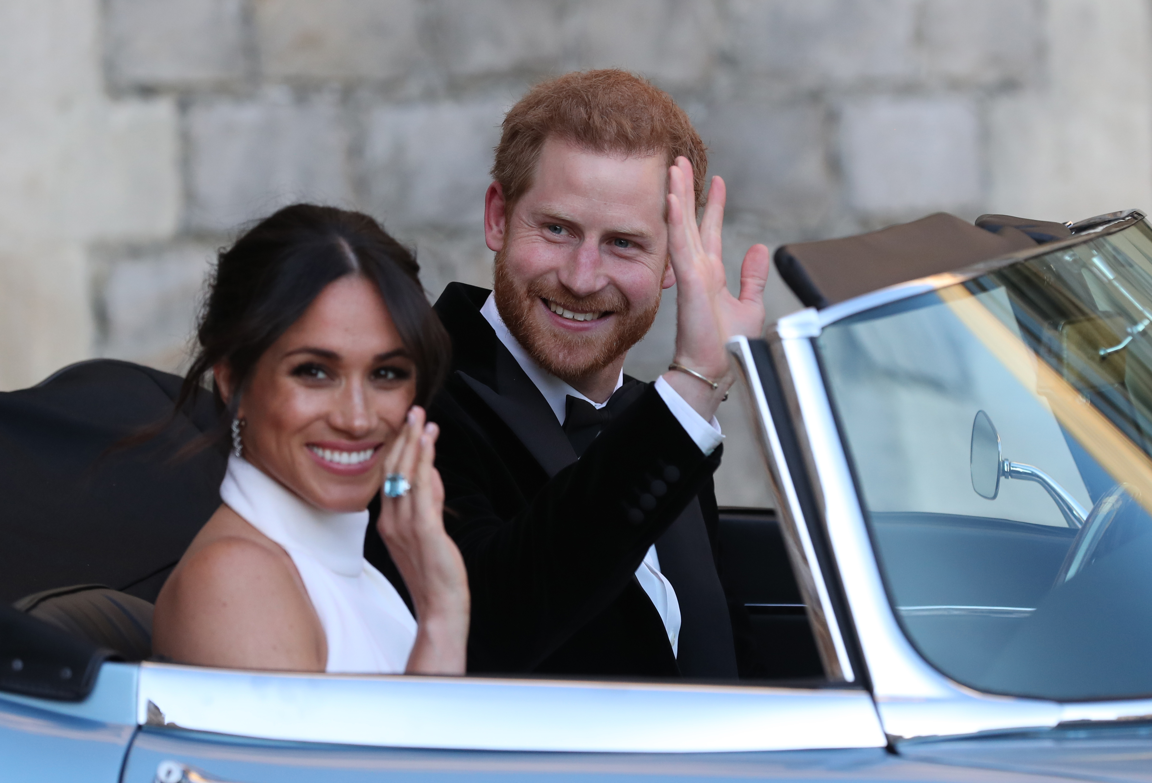 Prince Harry and Meghan Markle wave as they leave Windsor Castle, in Windsor, England, on May 19, 2018. | Source: Getty Images