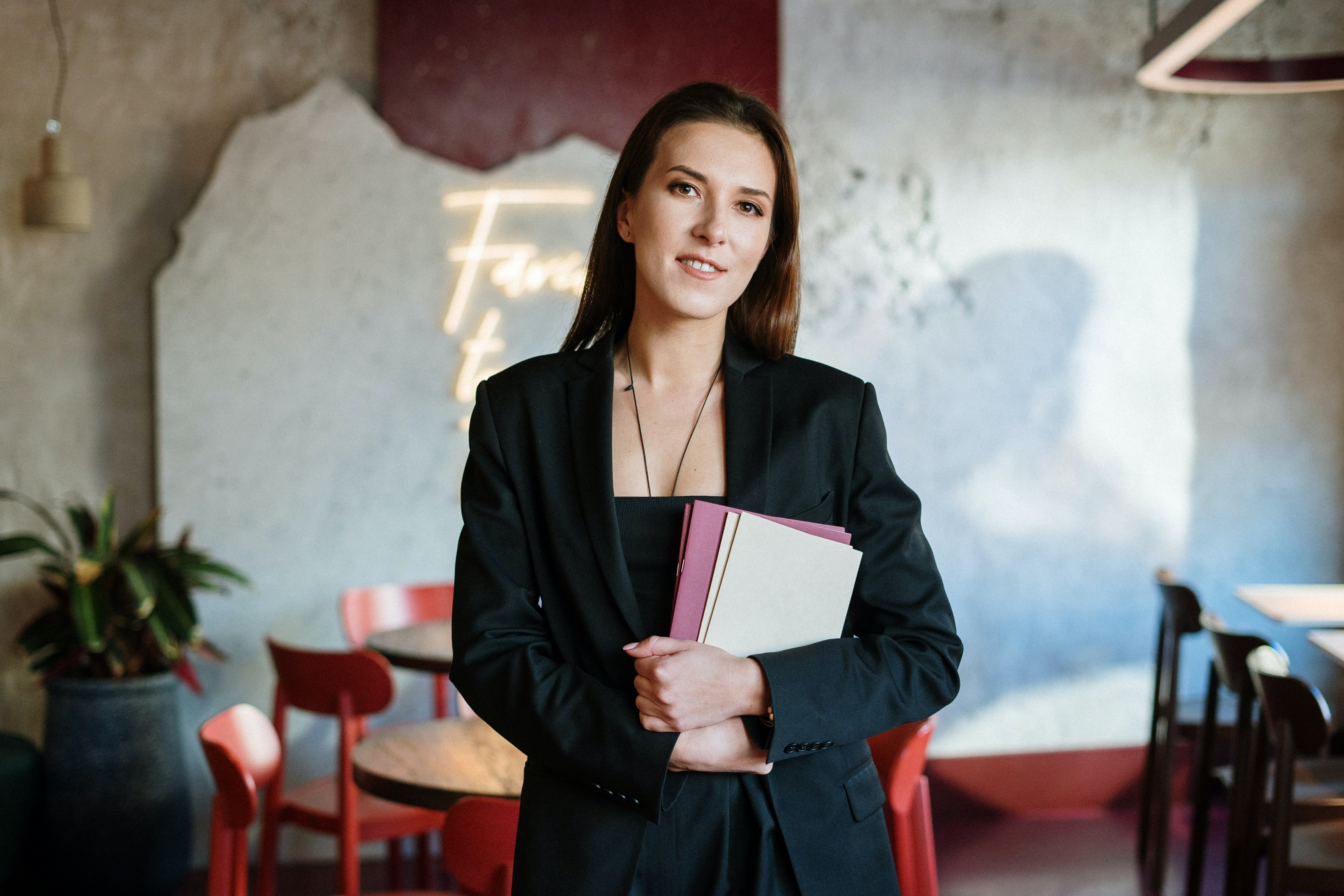 Woman in black blazer holding papers | Photo: Pexels