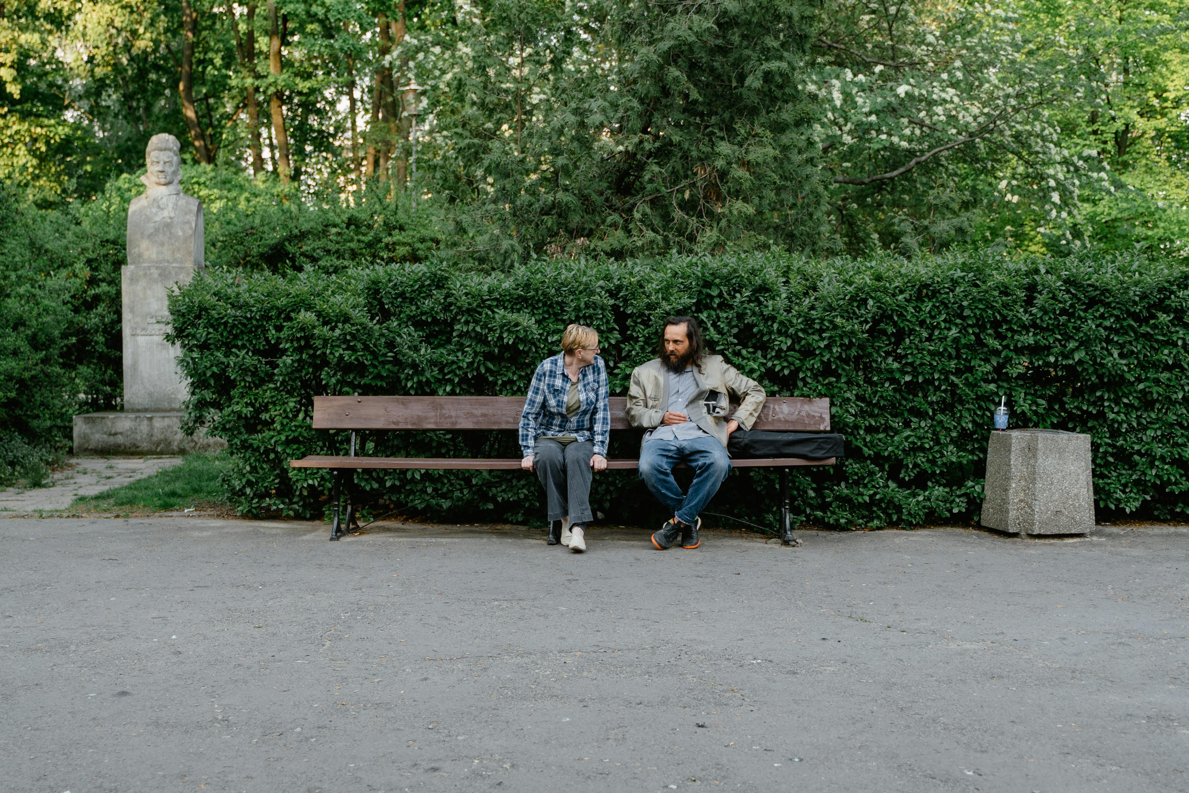 A woman talking to a destitute man in a park | Source: Pexels