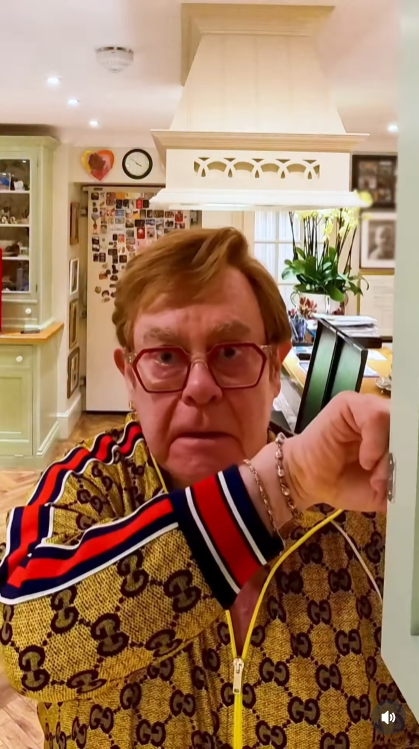 Sir Elton John opens a kitchen cabinet — and instantly freezes in horror as "Step Into Christmas" blares to life yet again. The singer's deadpan stare says it all: even in his own home, there's no escaping the festive chaos he accidentally unleashed. | Source: Instagram/eltonjohn