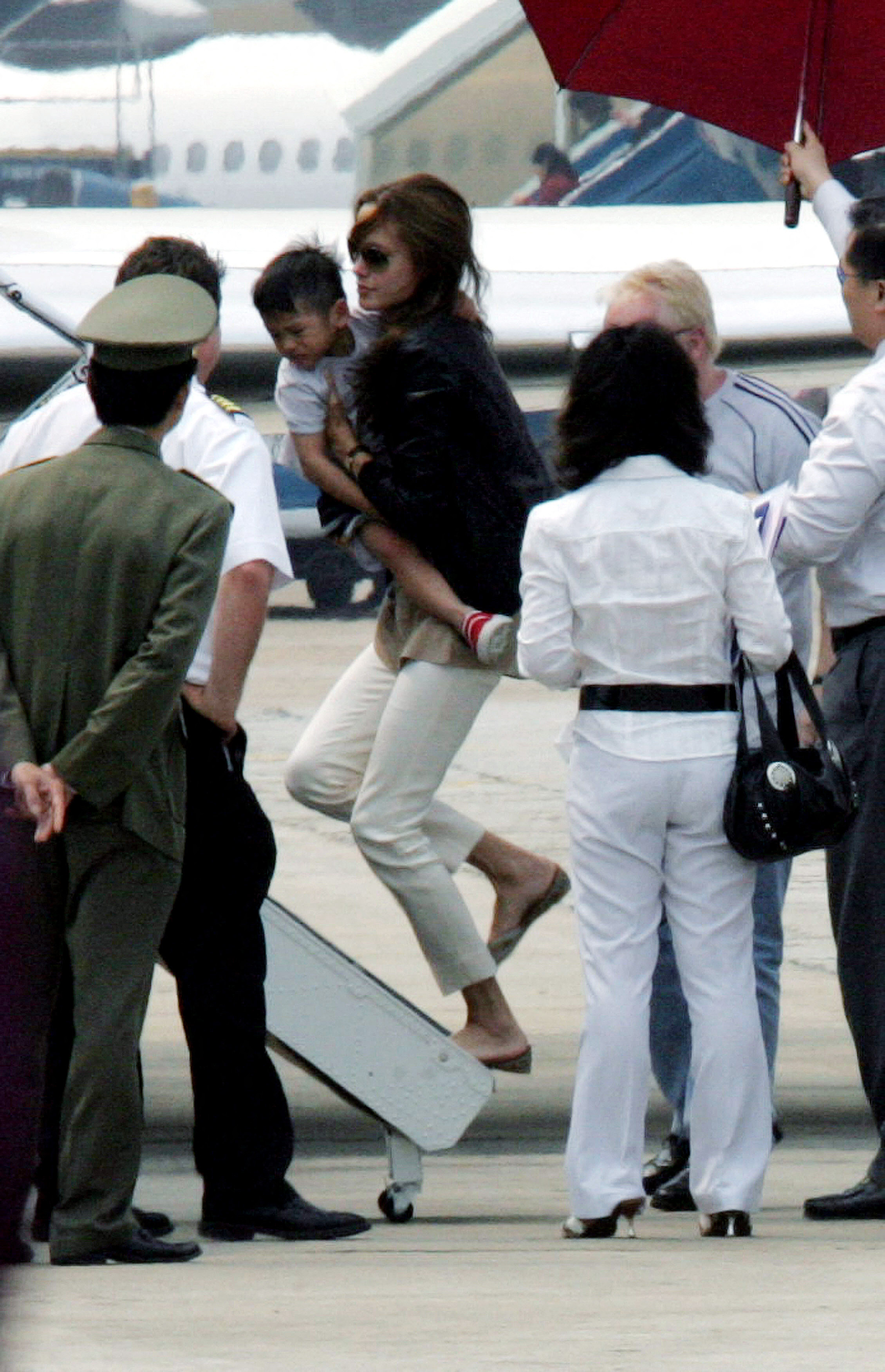 Angelina Jolie carries her newly adopted Vietnamese three-year-old son Pax Thien Jolie as she boards a jet at Hanoi's Noibai International airport to leave Vietnam, March 21, 2007 | Source: Getty Images