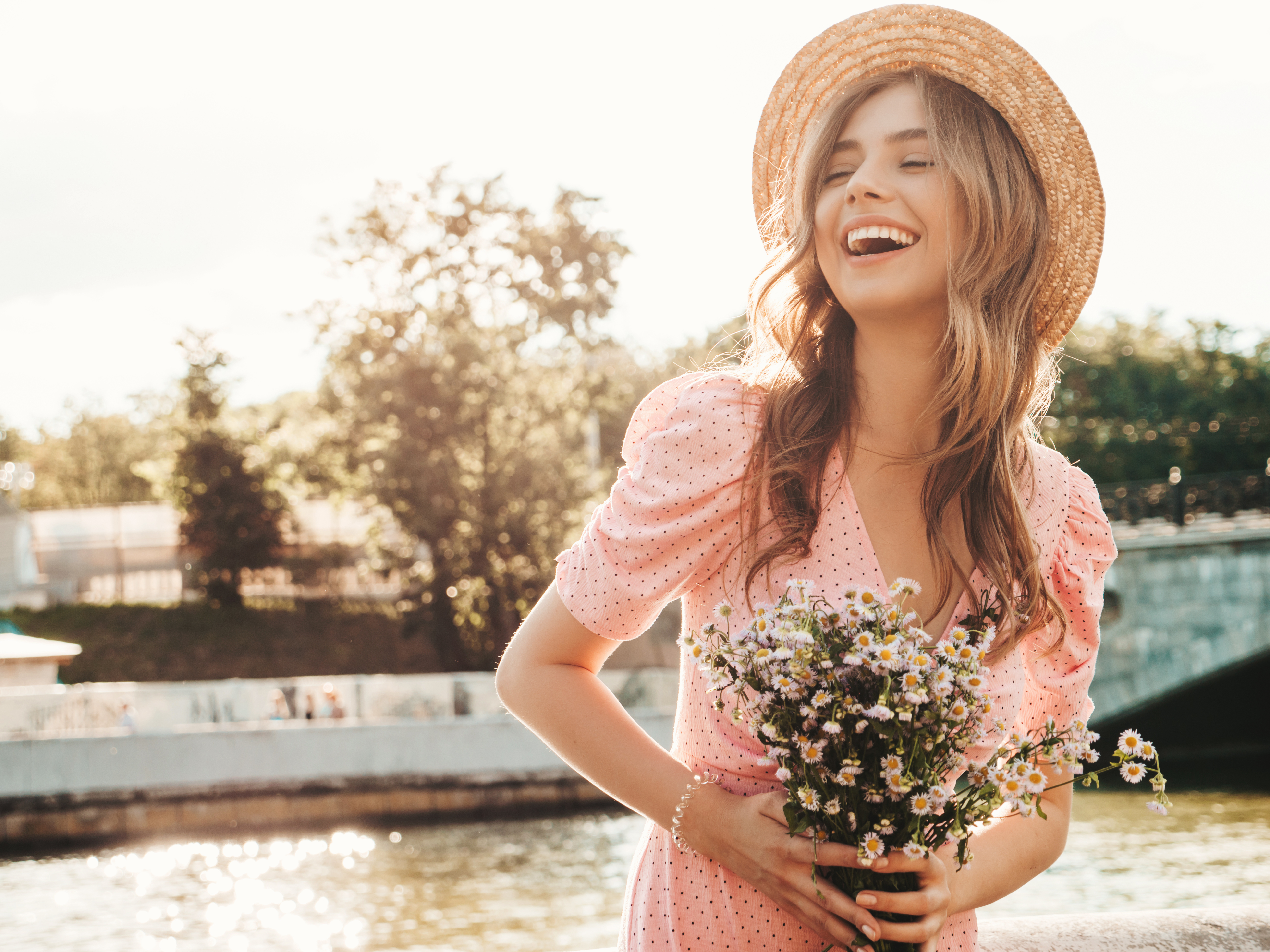 A smiling young woman holding flowers | Source: Shutterstock