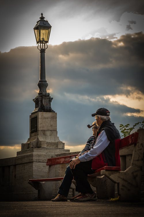 An elderly couple sit on a bench. | Source: Pexels