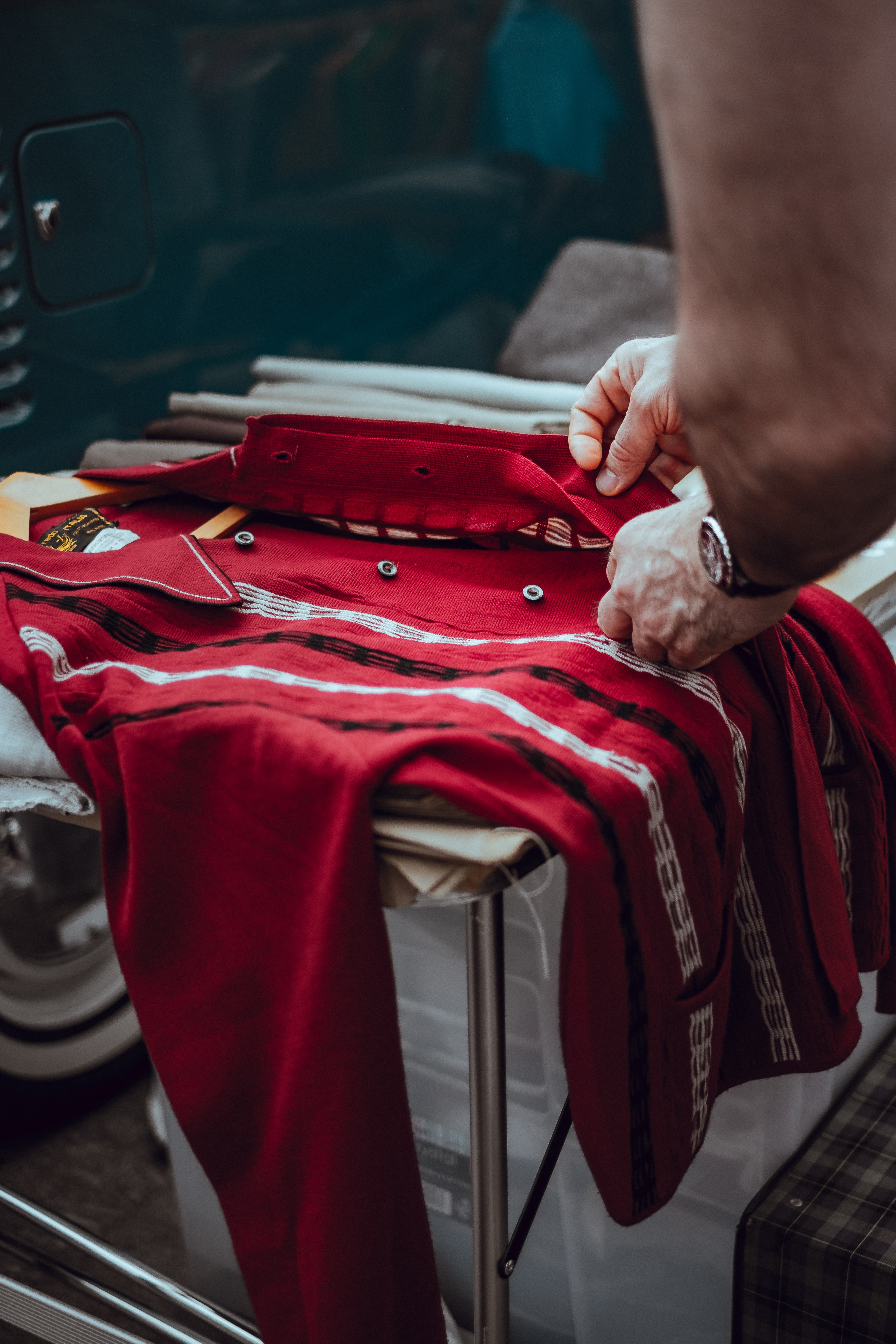 A person buttoning up a red shirt. | Source: Unsplash