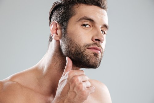 A young man examining his beard. | Source: Shutterstock. A young man examining his beard. | Source: Shutterstock.