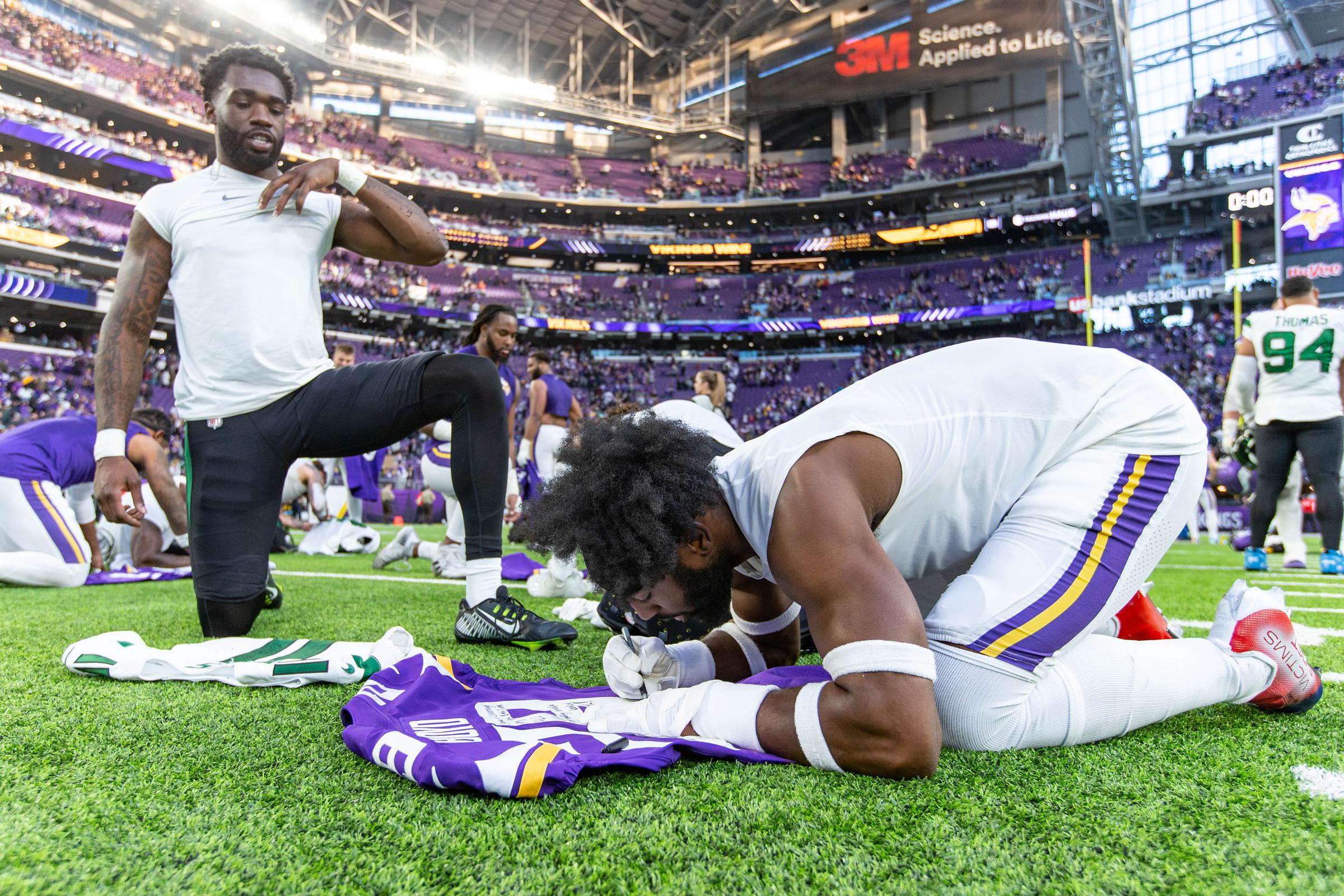Kris Boyd signs his jersey after a game at U.S. Bank Stadium, in Minneapolis, on December 4, 2022. | Source: Getty Images