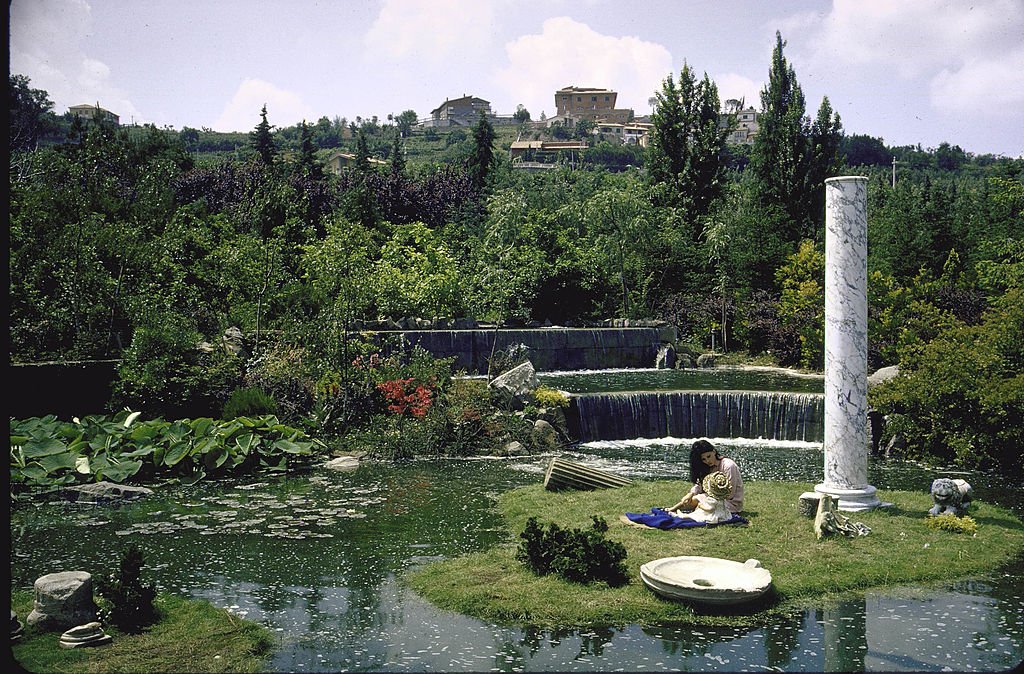 Sophia Loren joue avec sa nièce sur la petite île de l'étang artificiel sur le terrain de sa villa. | Photo : Getty Images