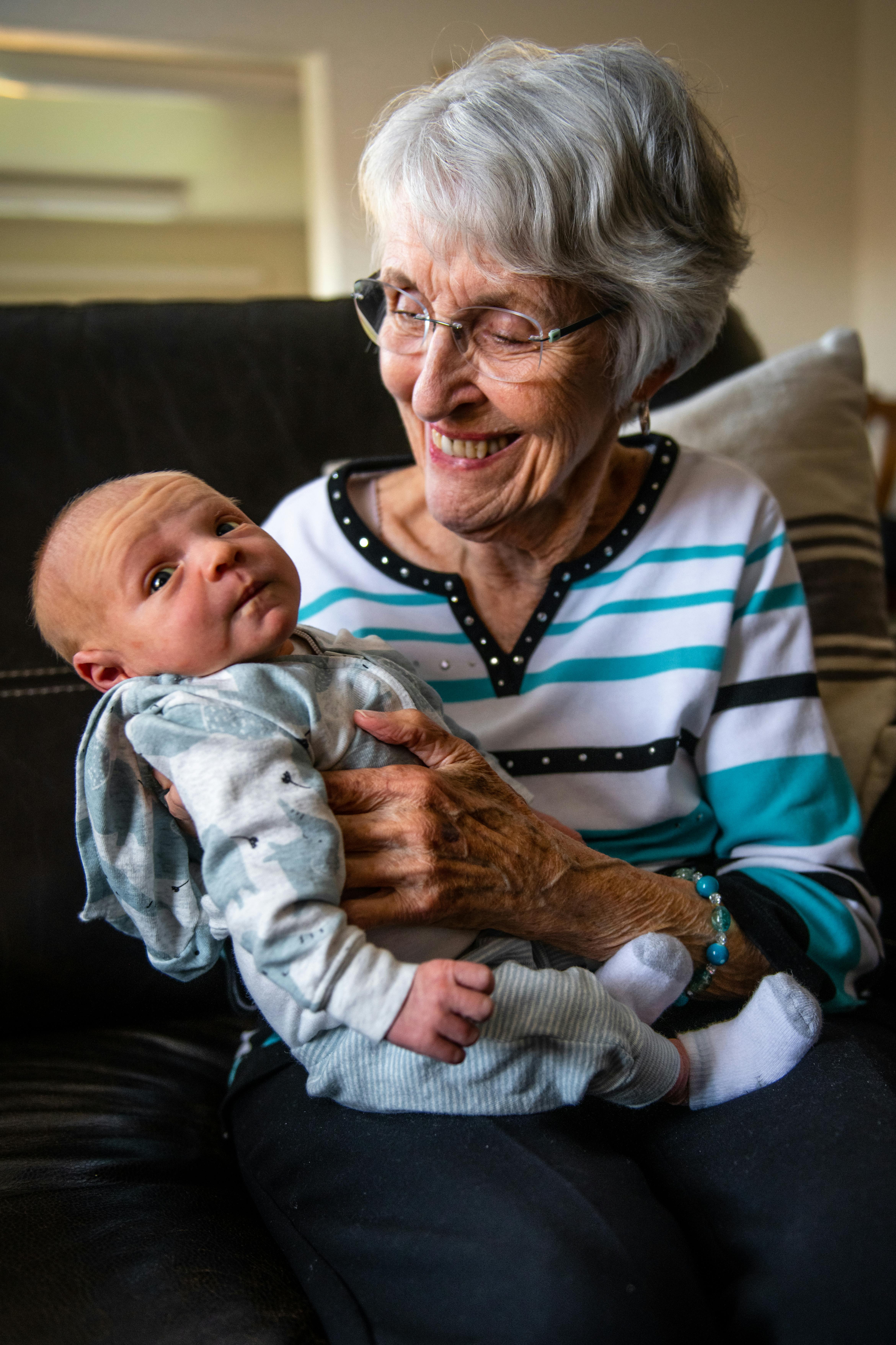 An elderly woman playing with a baby | Source: Pexels