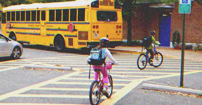 Una niña en bicicleta y un autobús escolar | Foto: Shutterstock