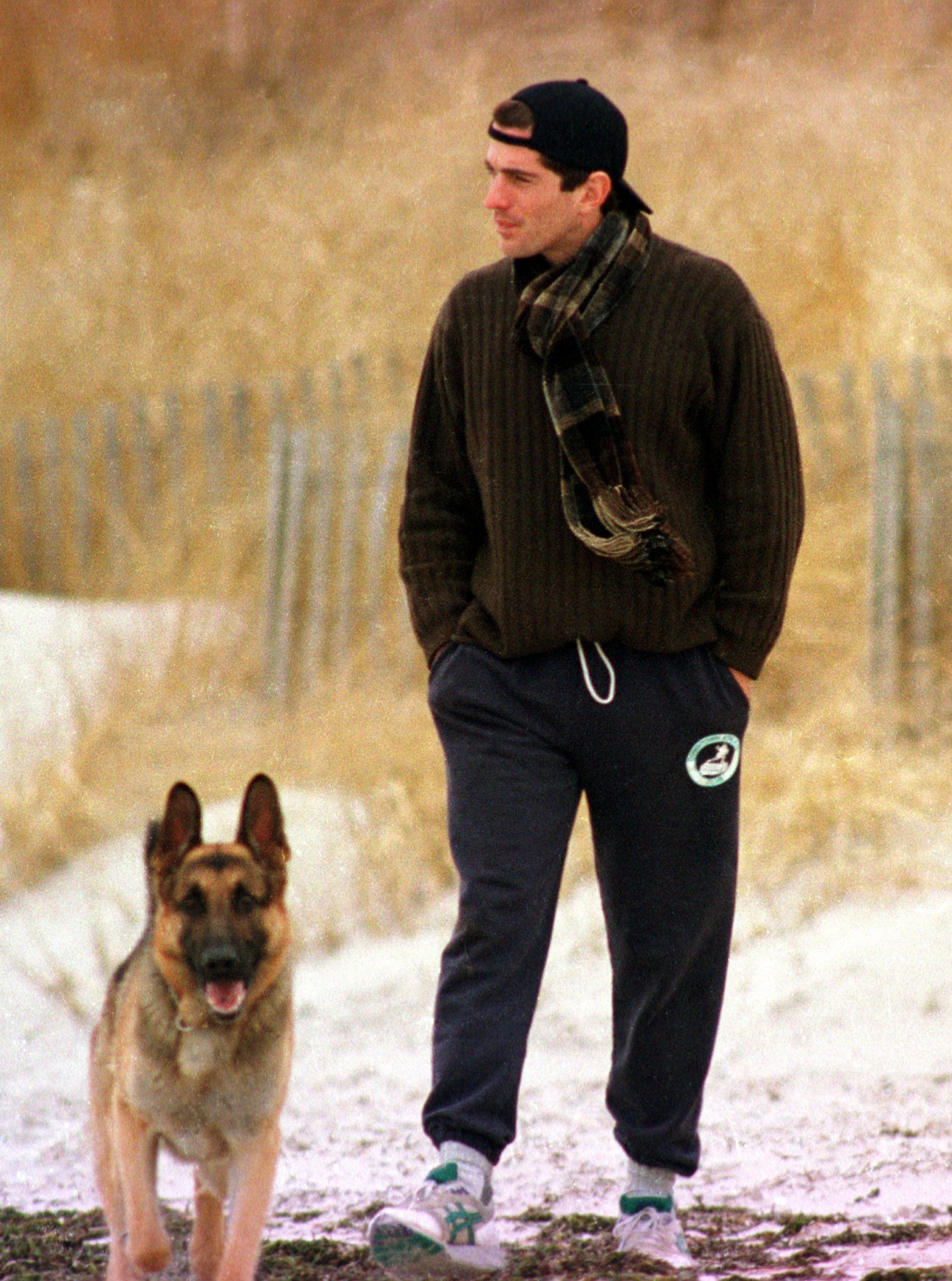 John F. Kennedy Jr. looks out to sea while walking with his dog along the beach in Hyannis Port, Massachusetts, January 24, 1995 | Photo: Getty Images