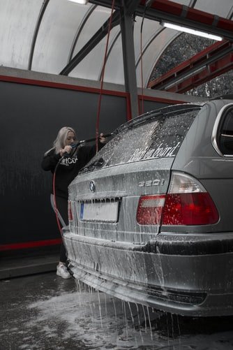 Une femme entrain de laver une voiture. | Photo : Unsplash