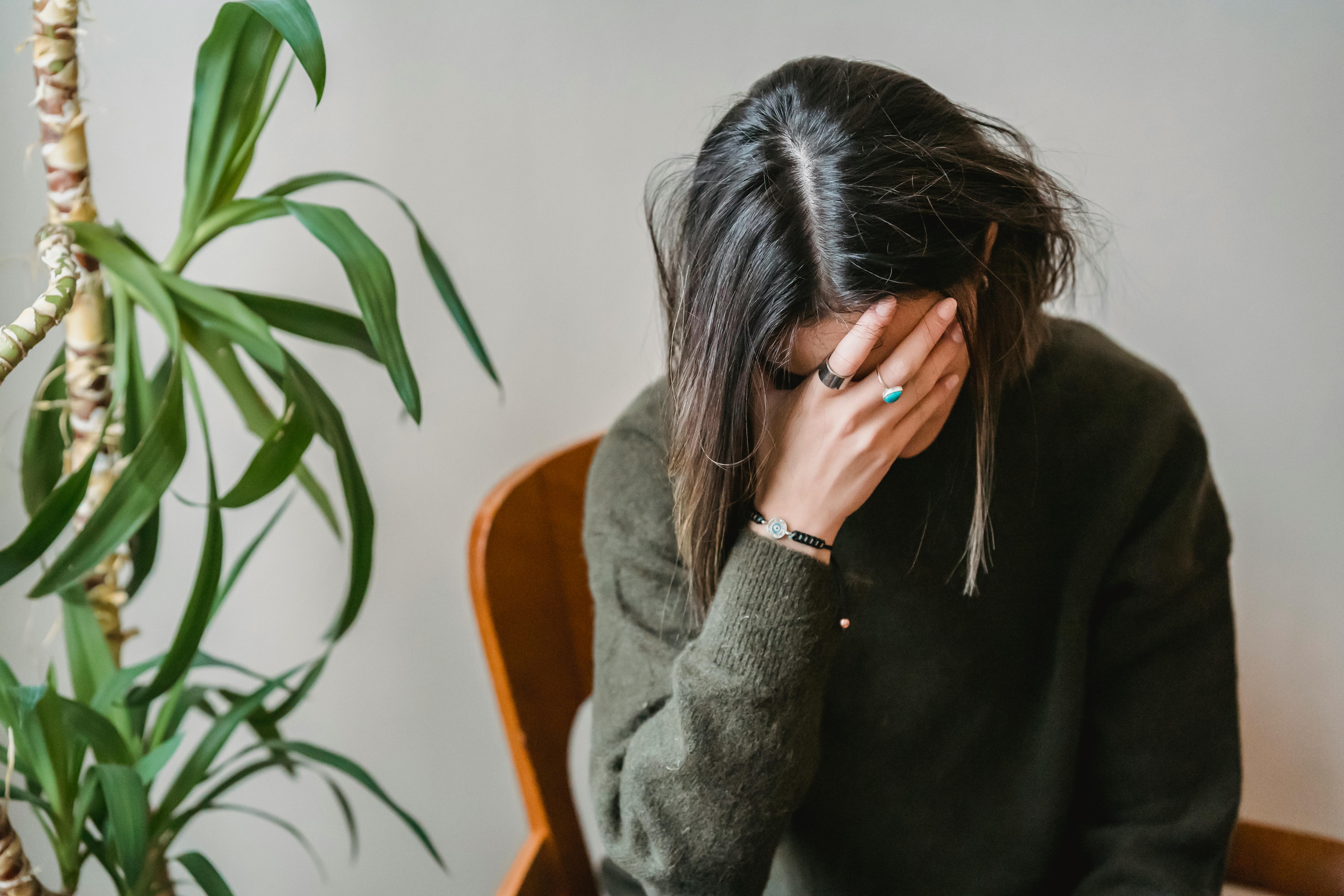 An upset woman with her head in her hands | Source: Pexels