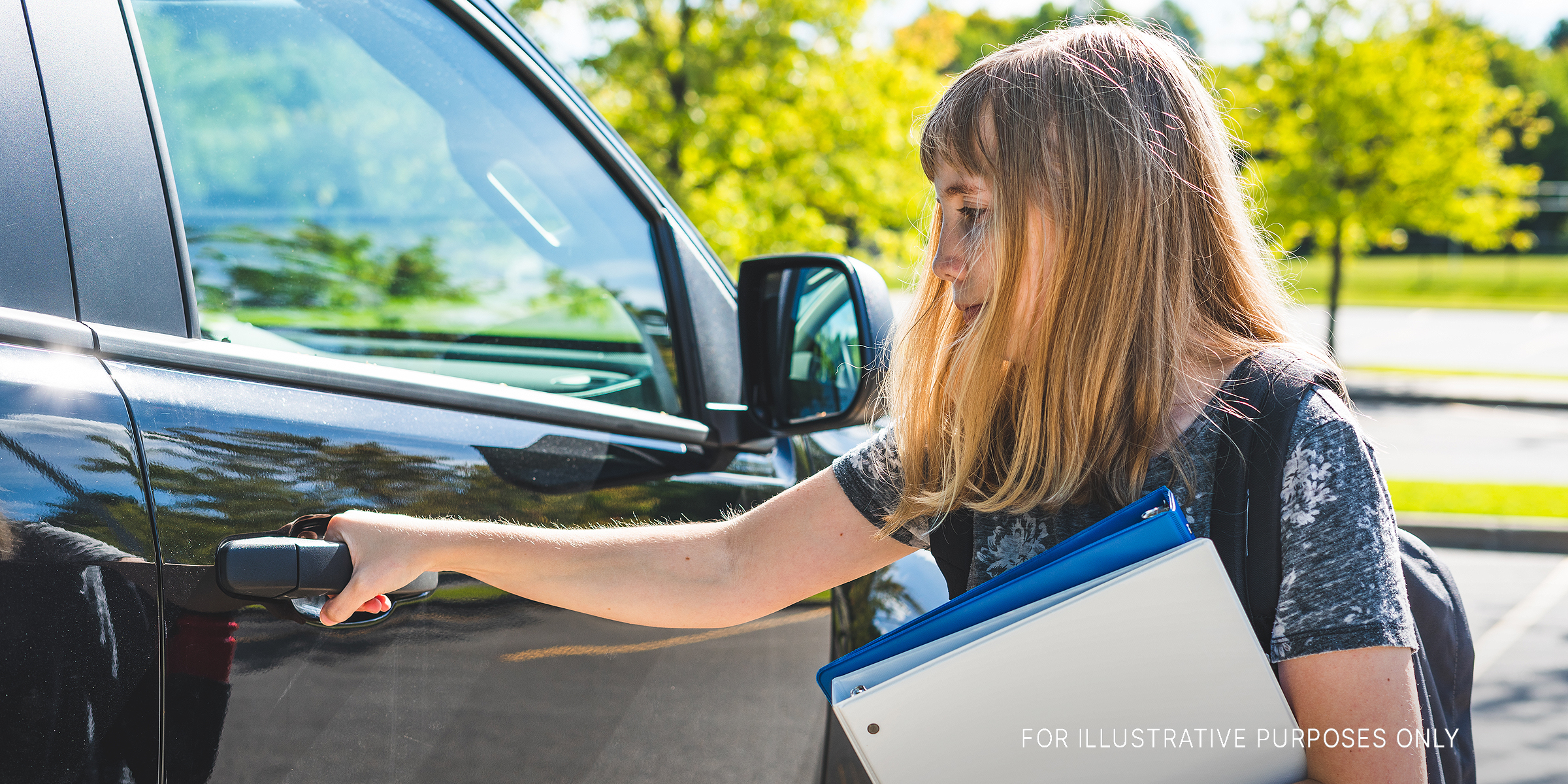 A teenage girl standing beside a car | Source: Shutterstock
