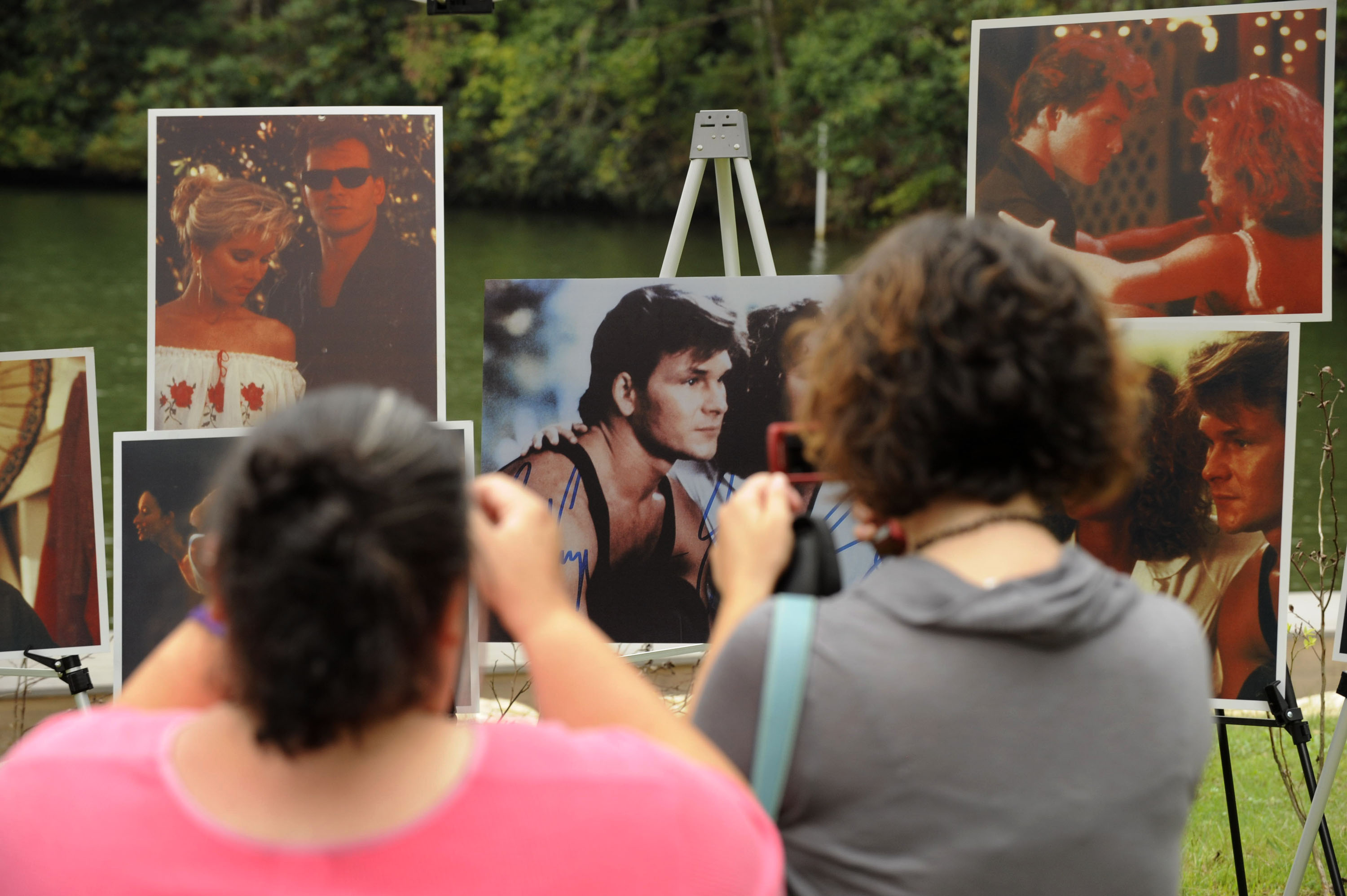 Fans photograph a gallery of images showing Patrick Swayze and Jennifer Grey from the movie "Dirty Dancing" prior to his memorial service on September 19, 2009, in Lake Lure, North Carolina. | Source: Getty Images