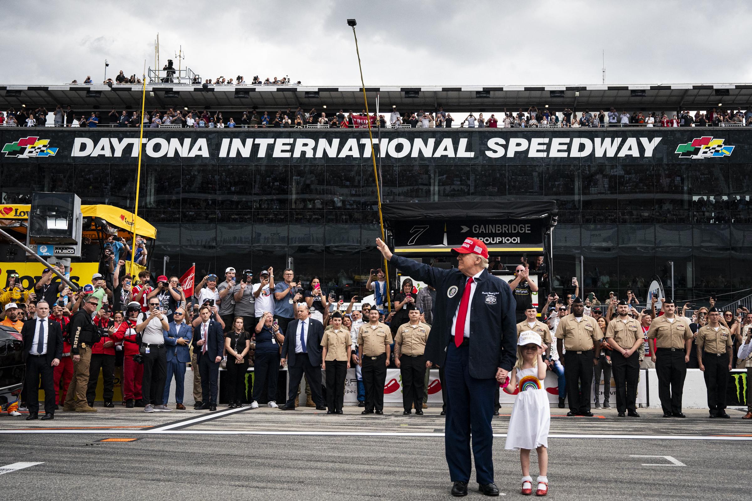 President Donald Trump, accompanied by his granddaughter Carolina Trump, greets attendees prior to riding in the Presidential limousine ahead of the start of the Daytona 500 Nascar race at Daytona International Speedway in Daytona Beach, Florida, on February 16, 2025 | Source: Getty Images