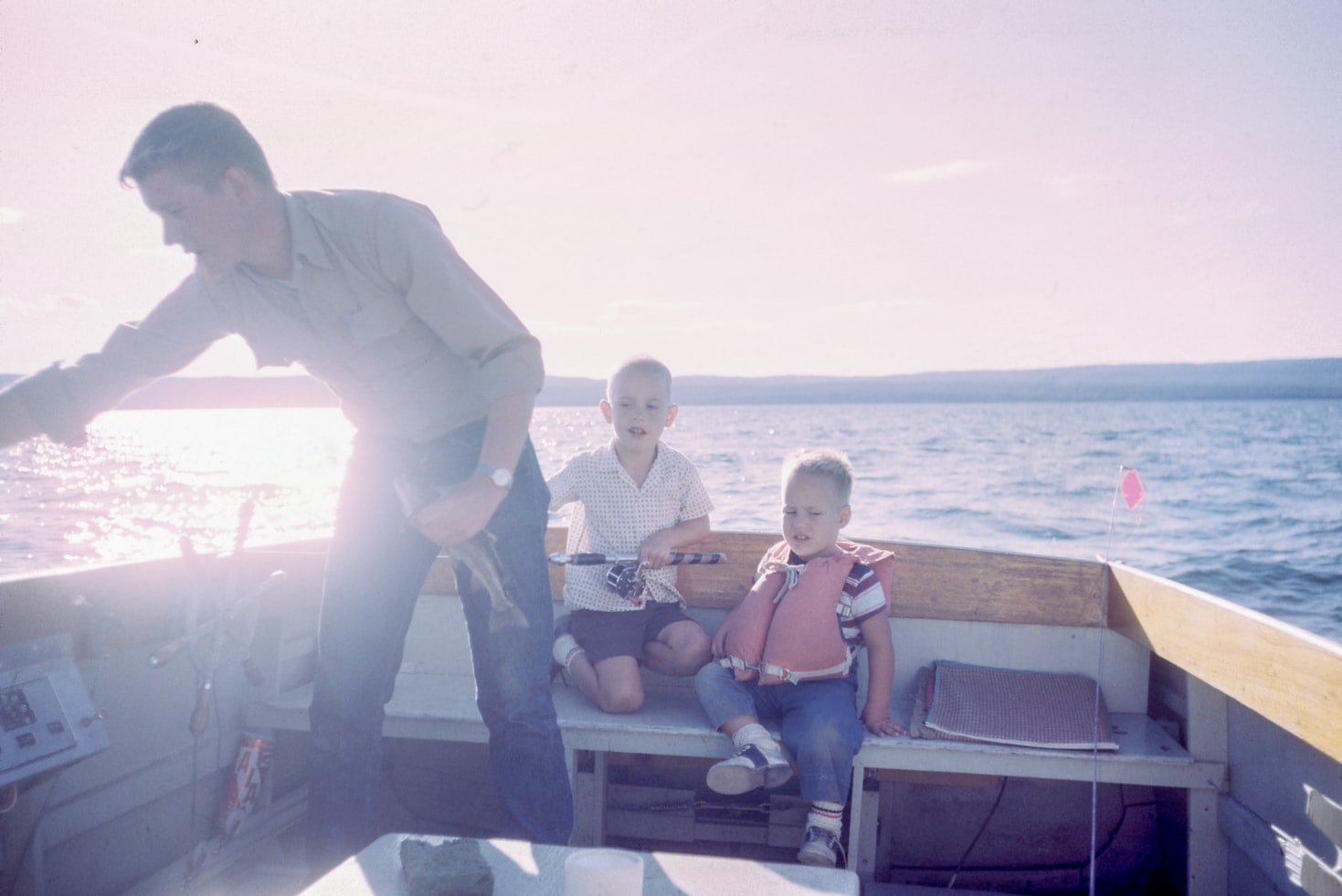 Un padre y sus dos hijos en una embarcación. | Foto: Unsplash