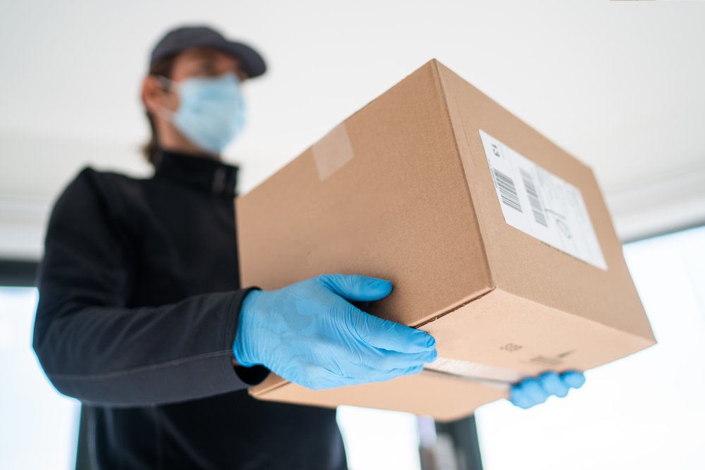 A photo of a delivery man carrying a box | Photo: Shutterstock