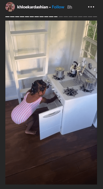 A photo of True squatting to pick an item. | Photo: Instagram/Khloekardashian