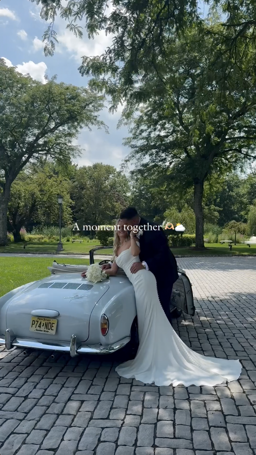 Victoria Schultz and Jon Runyan Jr. posing by a vintage car on their wedding day, posted on July 10, 2024 | Source: Instagram/antpagephoto, alenkafilms and victoriajrunyan