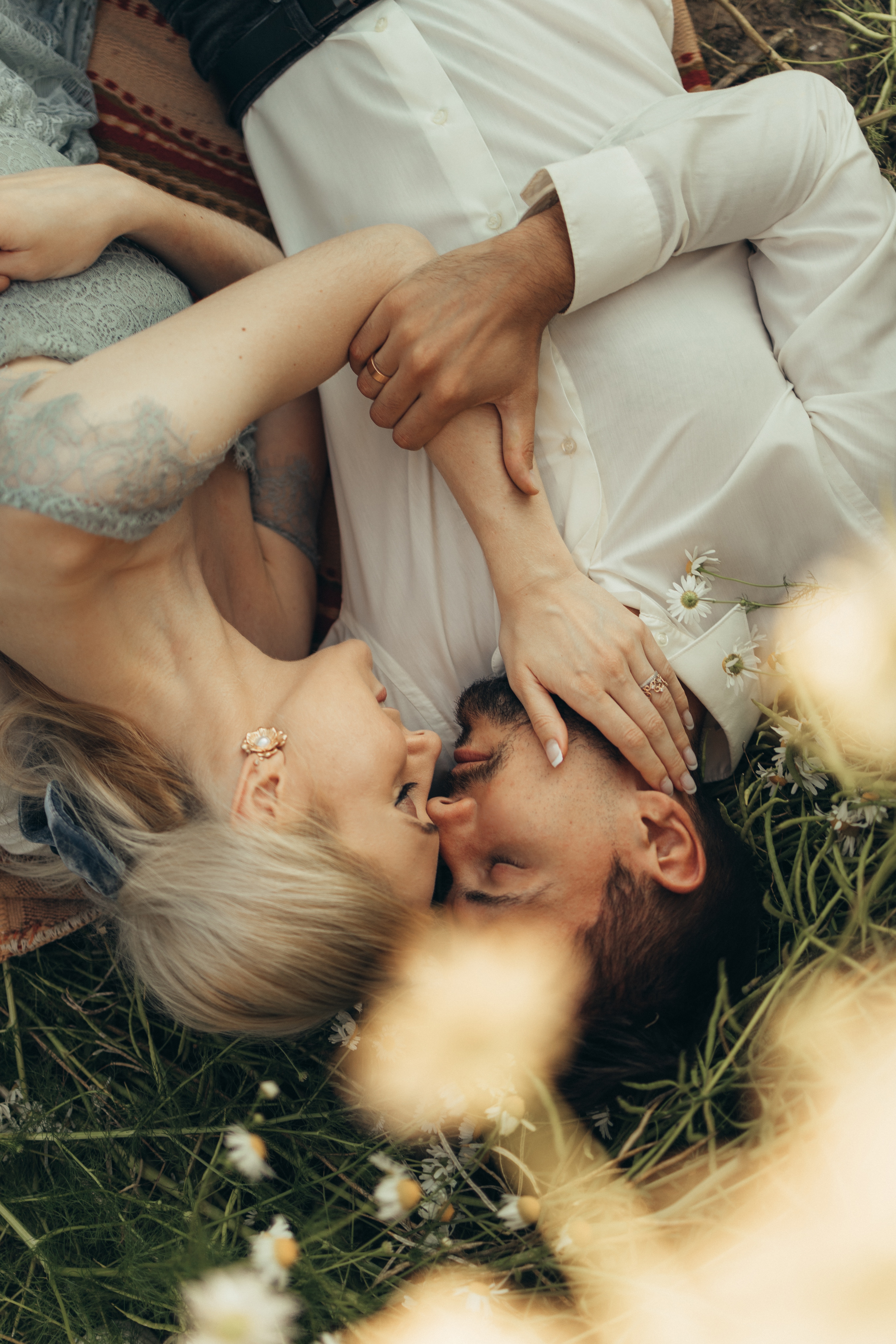 A couple lies down on the grass. | Source: Pexels