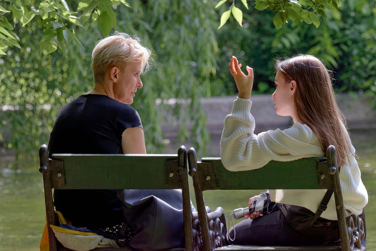 Mother and daughter talking on lakeshore in a park | Source: Pixabay