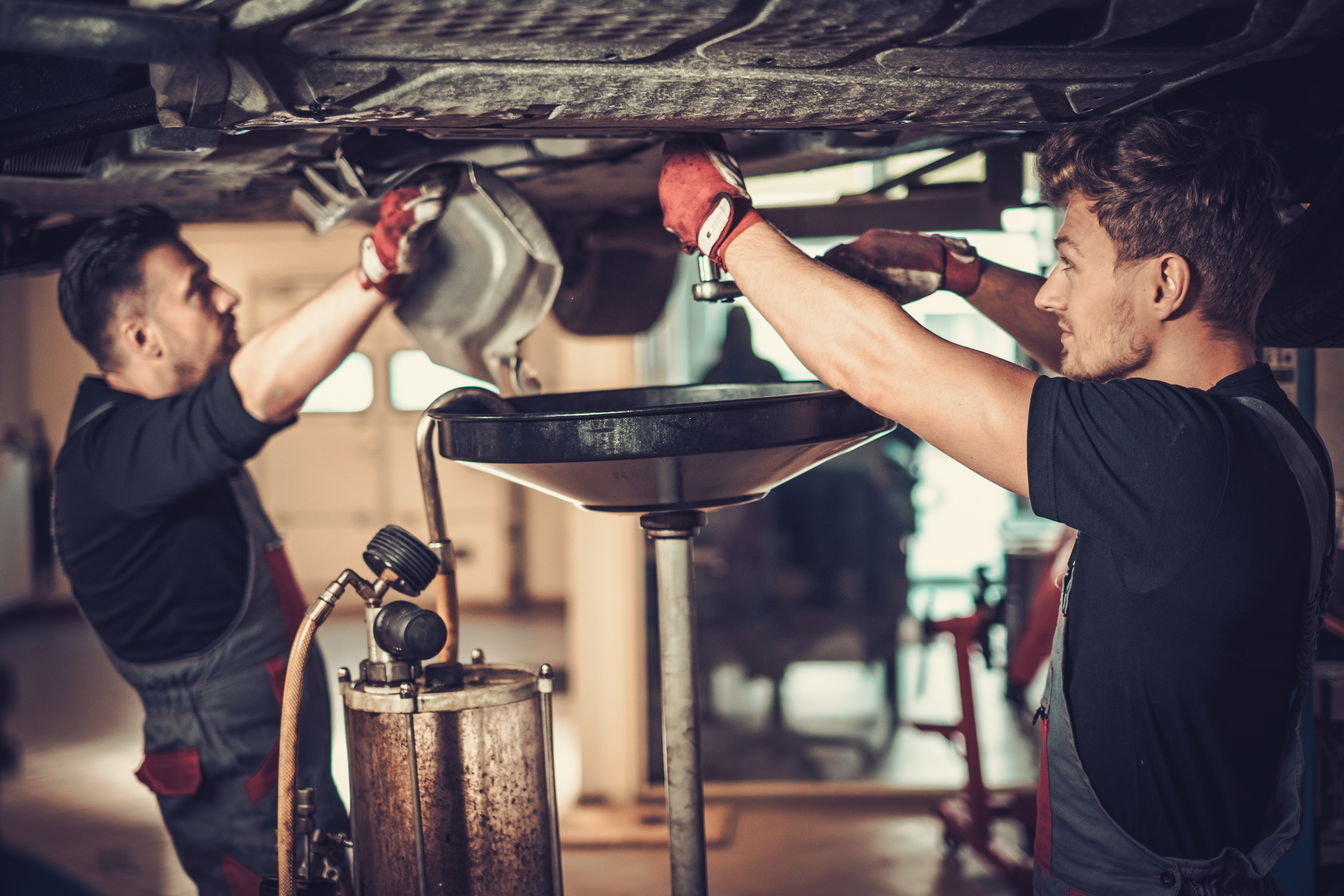 Profecional car mechanic changing motor oil in automobile engine at maintenance repair service station in a car workshop | Source: Shutterstock