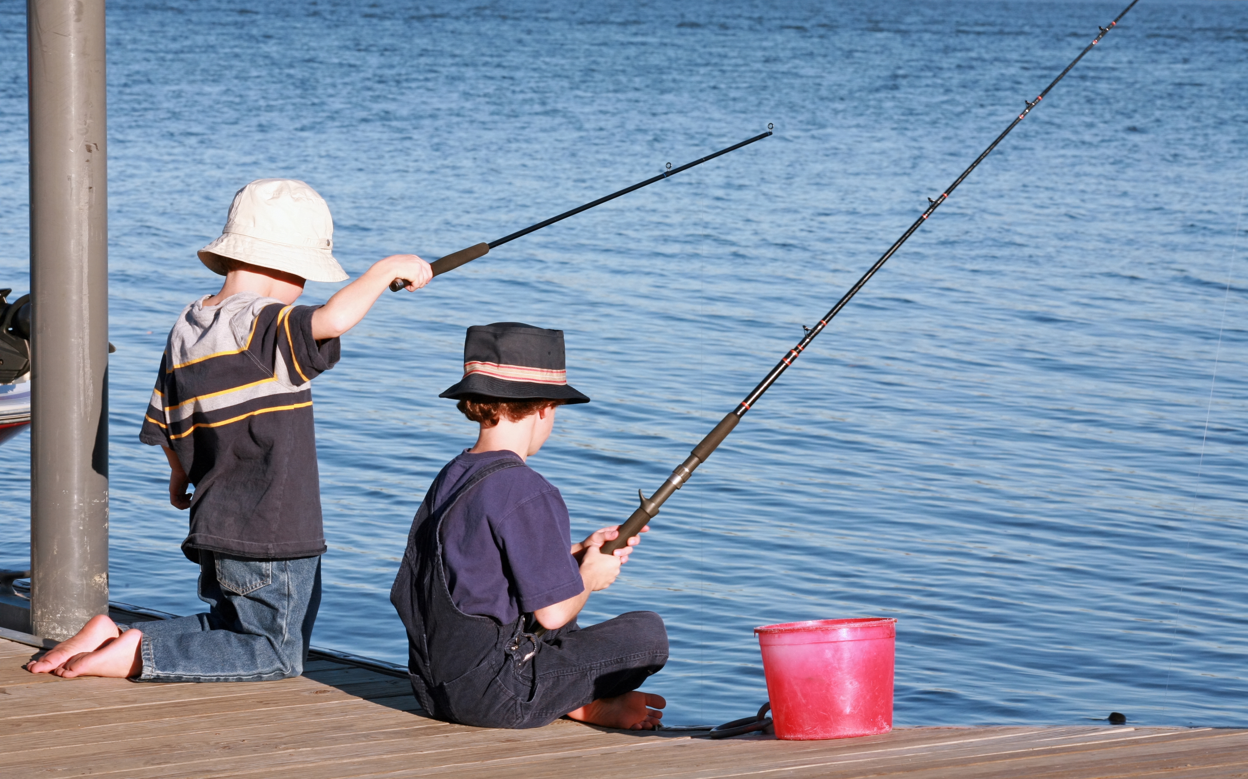 Two young boys fishing off a pier | Source: Shutterstock
