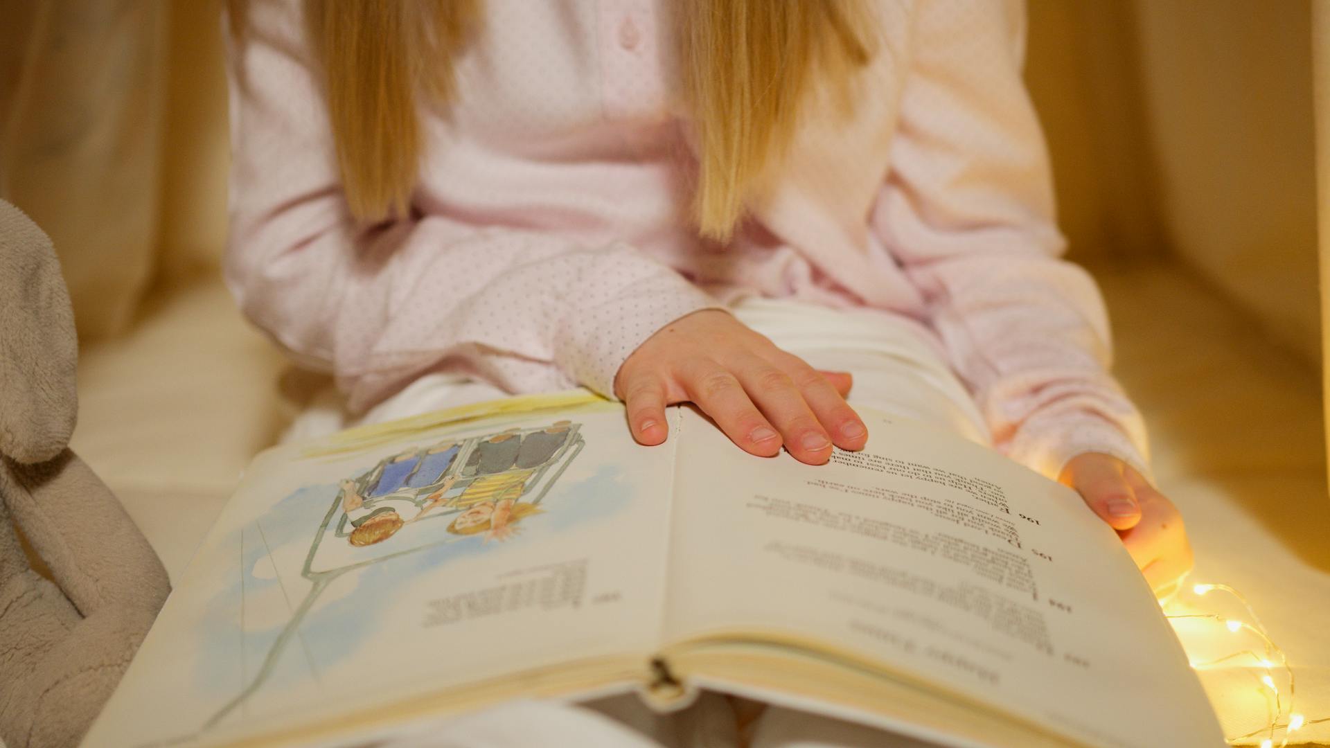 A little girl reading a book | Source: Pexels