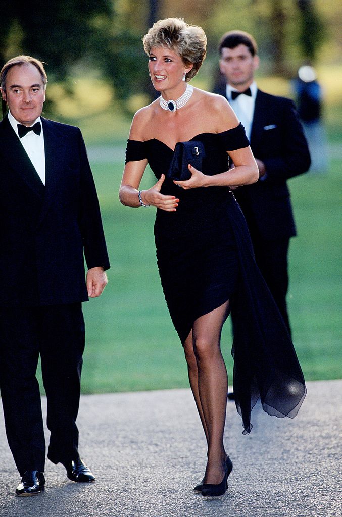 On June 29, 1994, Diana, former Princess of Wales, made headlines as she arrived at a gala at the Serpentine Gallery in Hyde Park wearing a striking black cocktail dress by Christina Stambolian. Dubbed the 'revenge dress' by the press, the daring, off-the-shoulder look made a powerful statement on the very evening King Charles III publicly admitted to infidelity.