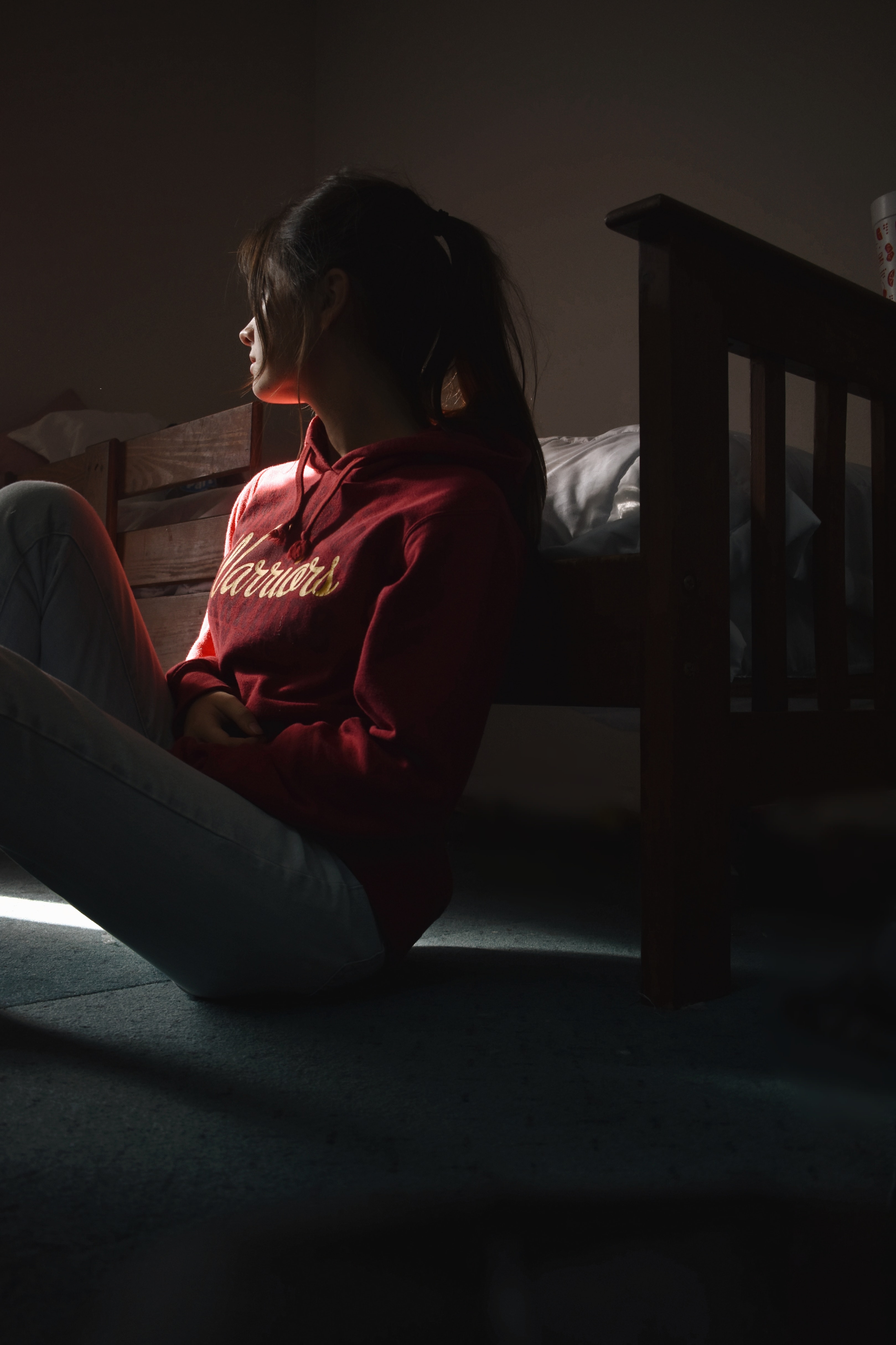 A woman sitting on her bedroom floor looking to one side | Source: Pexels