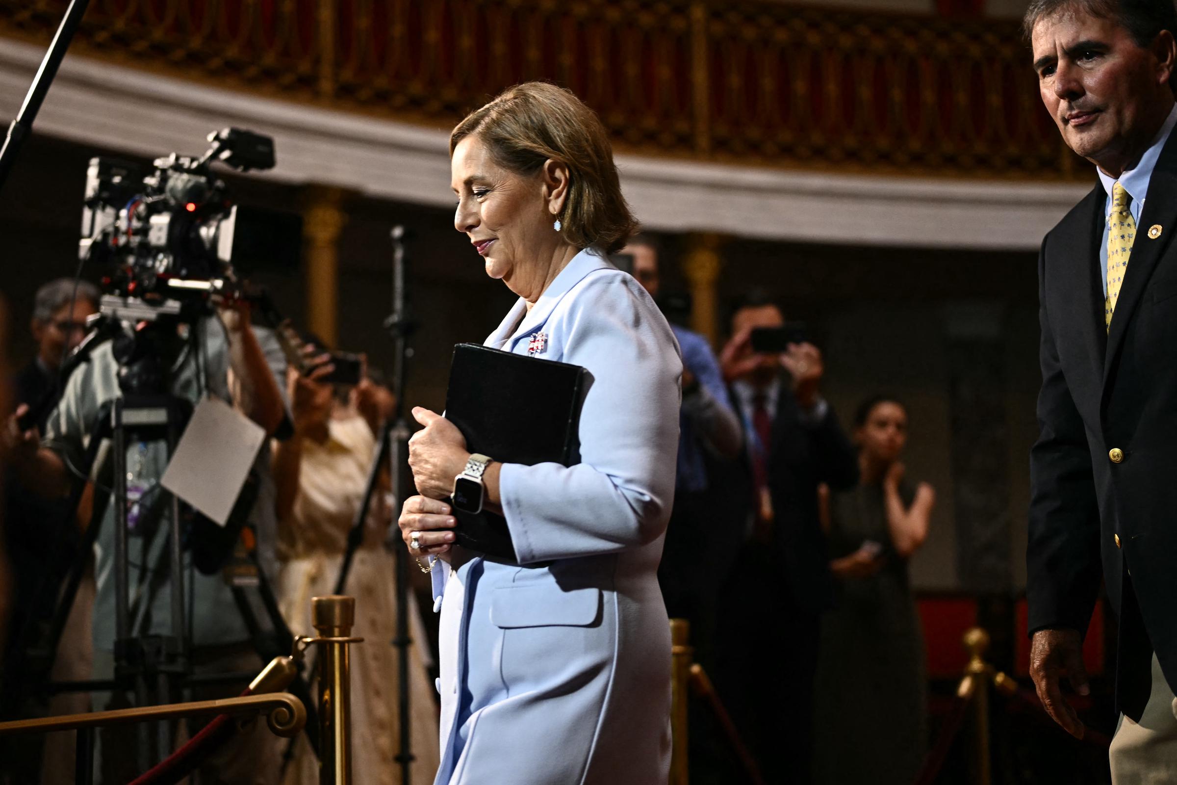 Clutching her Bible and surrounded by press cameras, Senator Darline Graham Nordone departs the Old Senate Chamber on July 14, 2026, stepping directly into her new role under the national spotlight. | Source: Getty Images