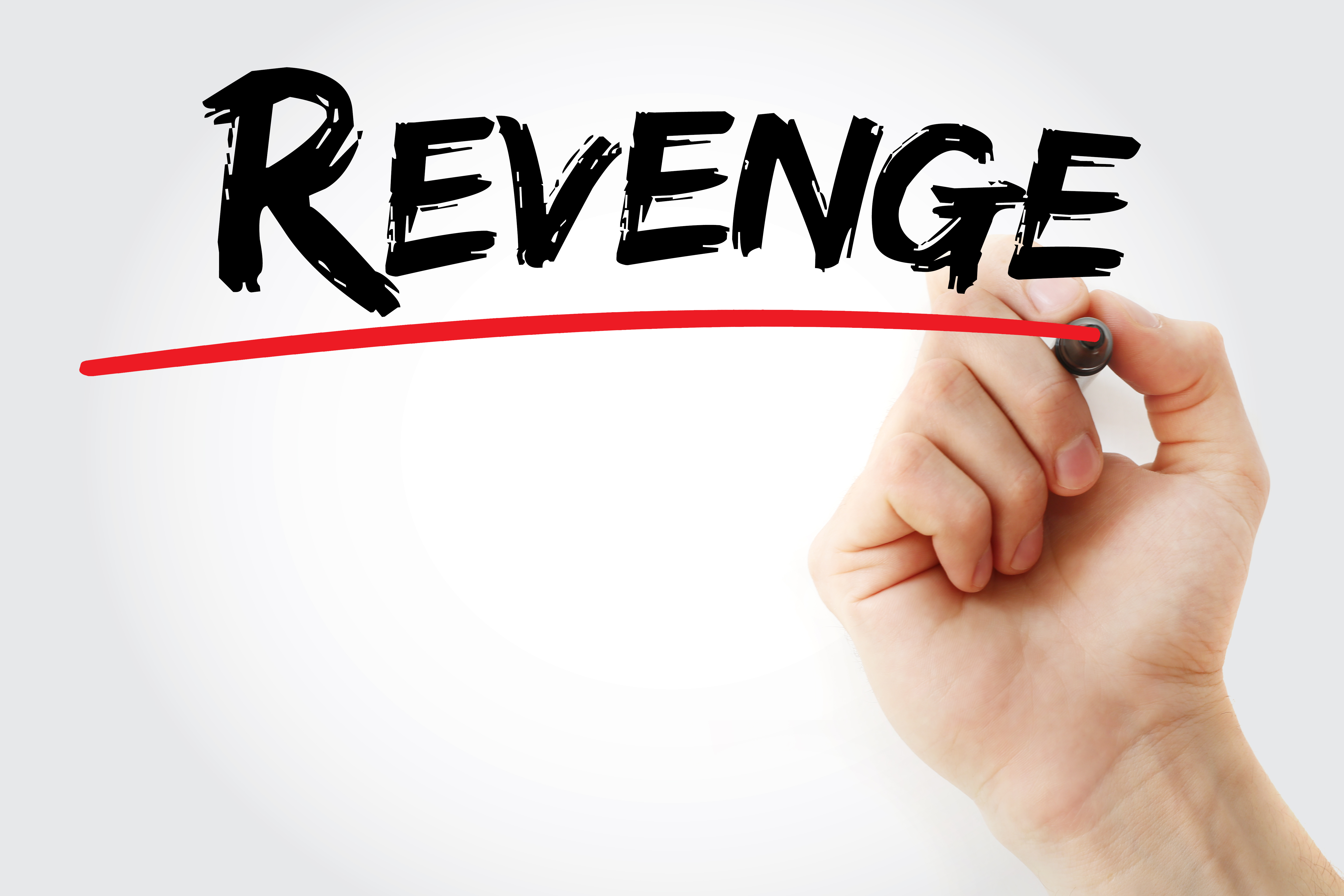 A hand writing the word "revenge" | Source: Shutterstock