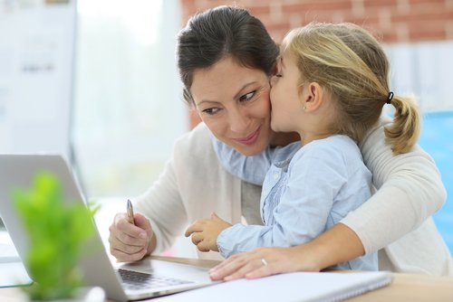 Madre comparte con su hija frente a la computadora. | Foto: Shutterstock