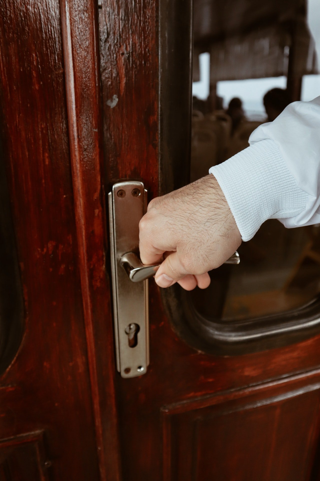 Una mano sobre la cerradura de una puerta. | Foto: Pexels