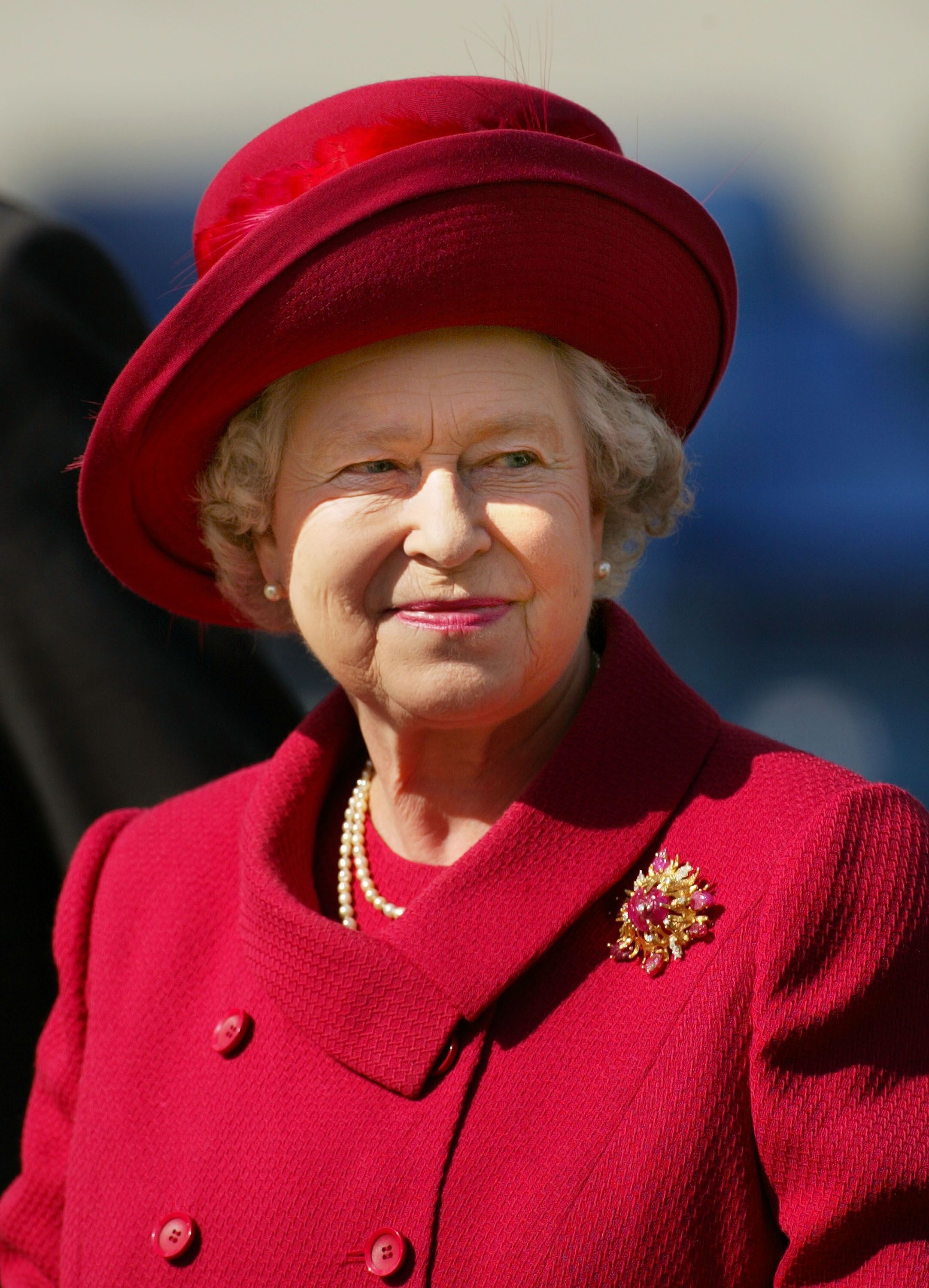 Queen Elizabeth smiles May 18, 2002 after presenting a trophy for the "best turned out trooper" to a Household Cavalry soldier at The Royal Windsor Horse Show at Windsor Great Park, England. | Source: Getty Images