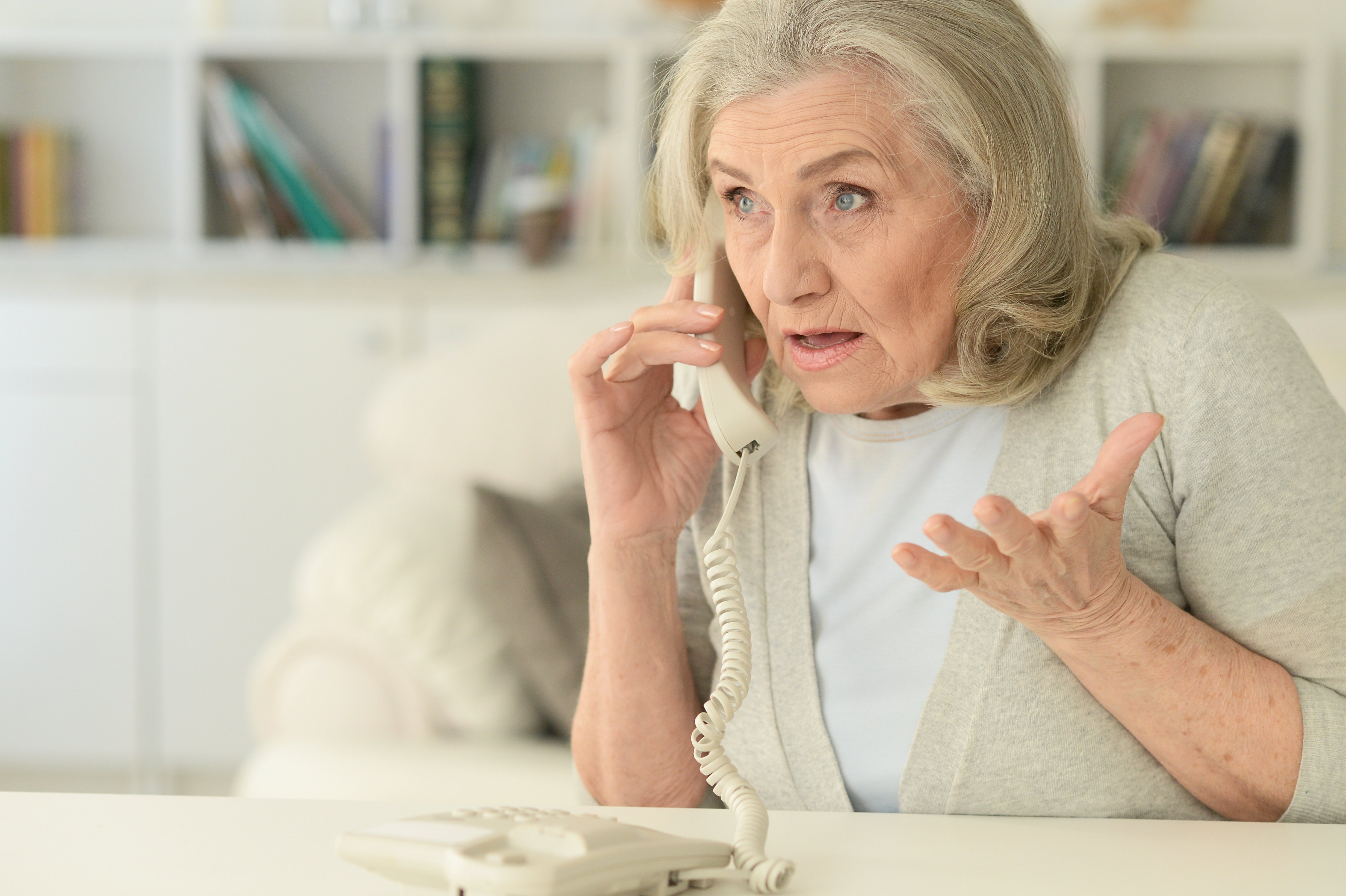 Una mujer mayor atiende una llamada que le angustia. | Foto: Shutterstock