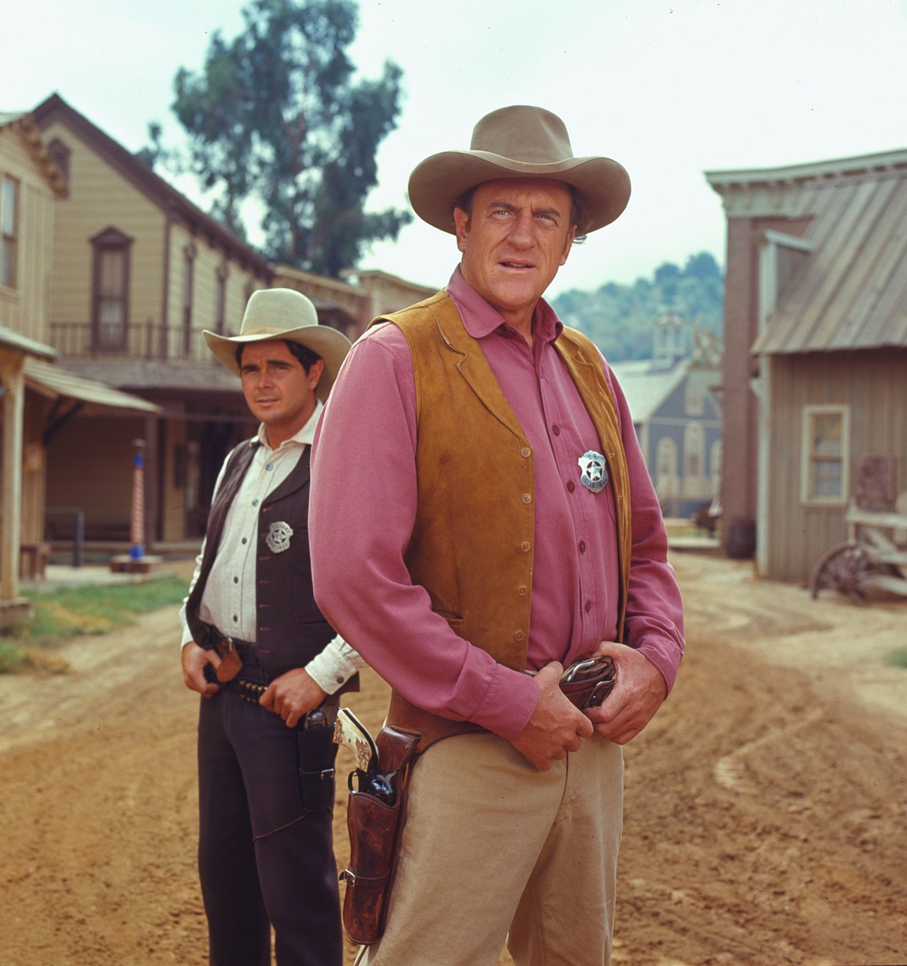 Promotional portrait of American actors James Arness (as U. S. Marshal Matt Dillon) (foreground) and Buck Taylor (as Newly O'Brien) from the television series 'Gunsmoke,' 1970. | Source: Getty Images